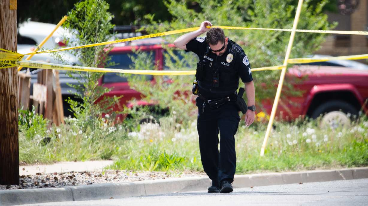 A Layton police officer crosses police tape at the scene of a triple homicide in Layton on Friday. The Layton man who police say killed three members of his family Friday — including his in-laws visiting from Nevada — could face the death penalty.