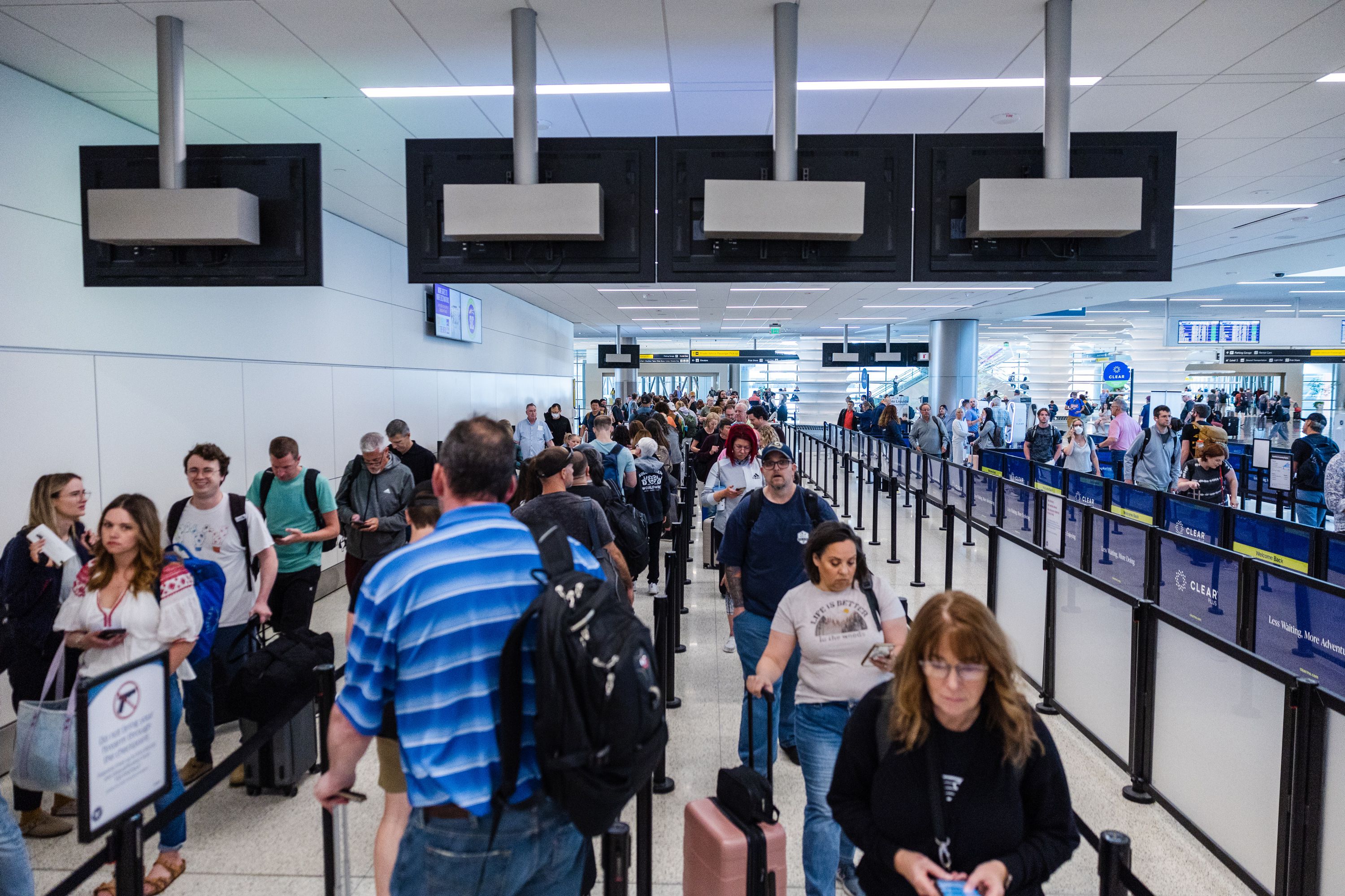 Travelers walk through security at the Salt Lake City International Airport in Salt Lake City on Friday. The upcoming Memorial Day weekend is projected to come in as one of the busiest since 2000.