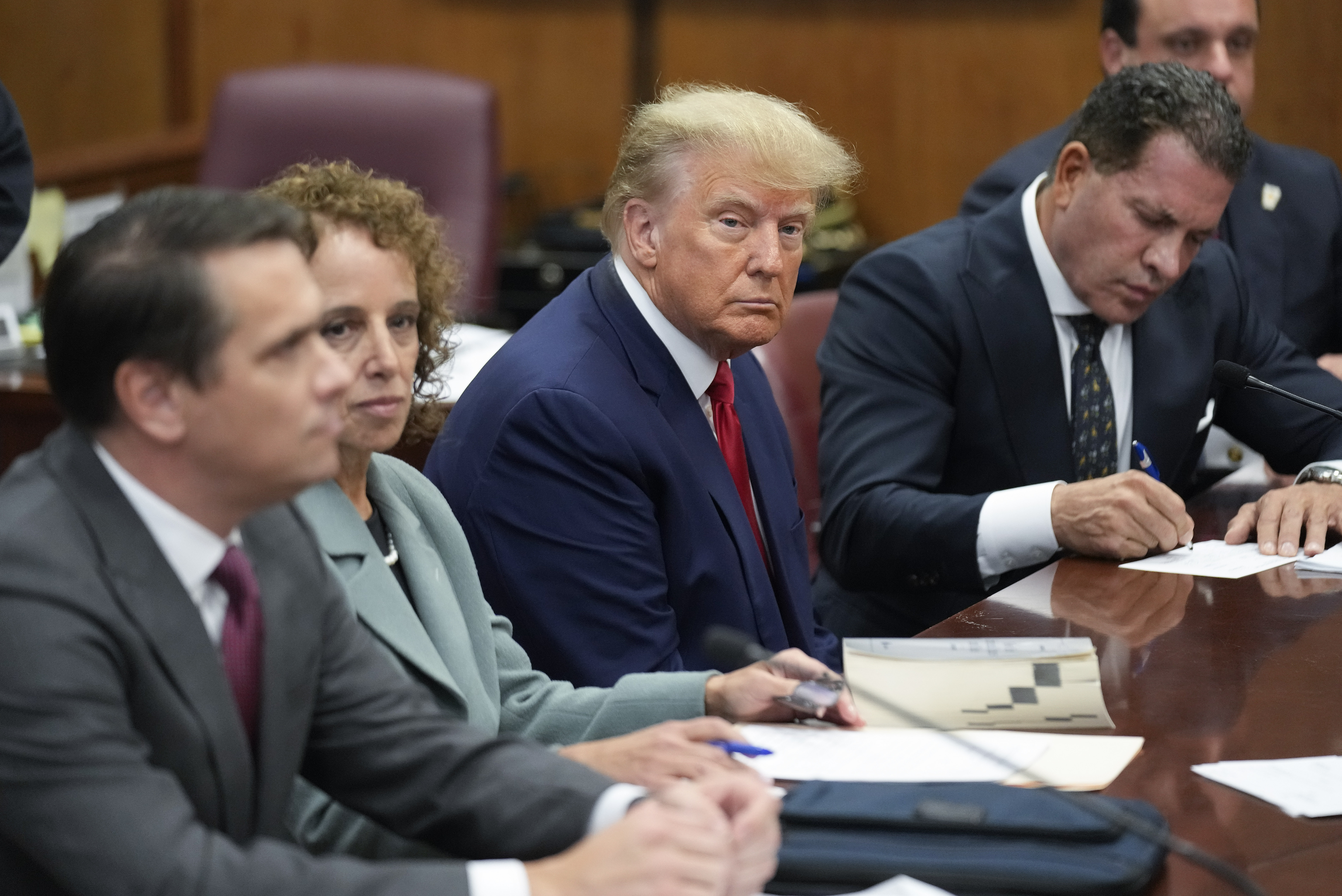 Former President Donald Trump with his legal team in a Manhattan court, April 4, in New York. The judge in Trump's case is holding a hybrid hearing Tuesday to make sure he's aware of new rules barring him from using evidence to attack witnesses.