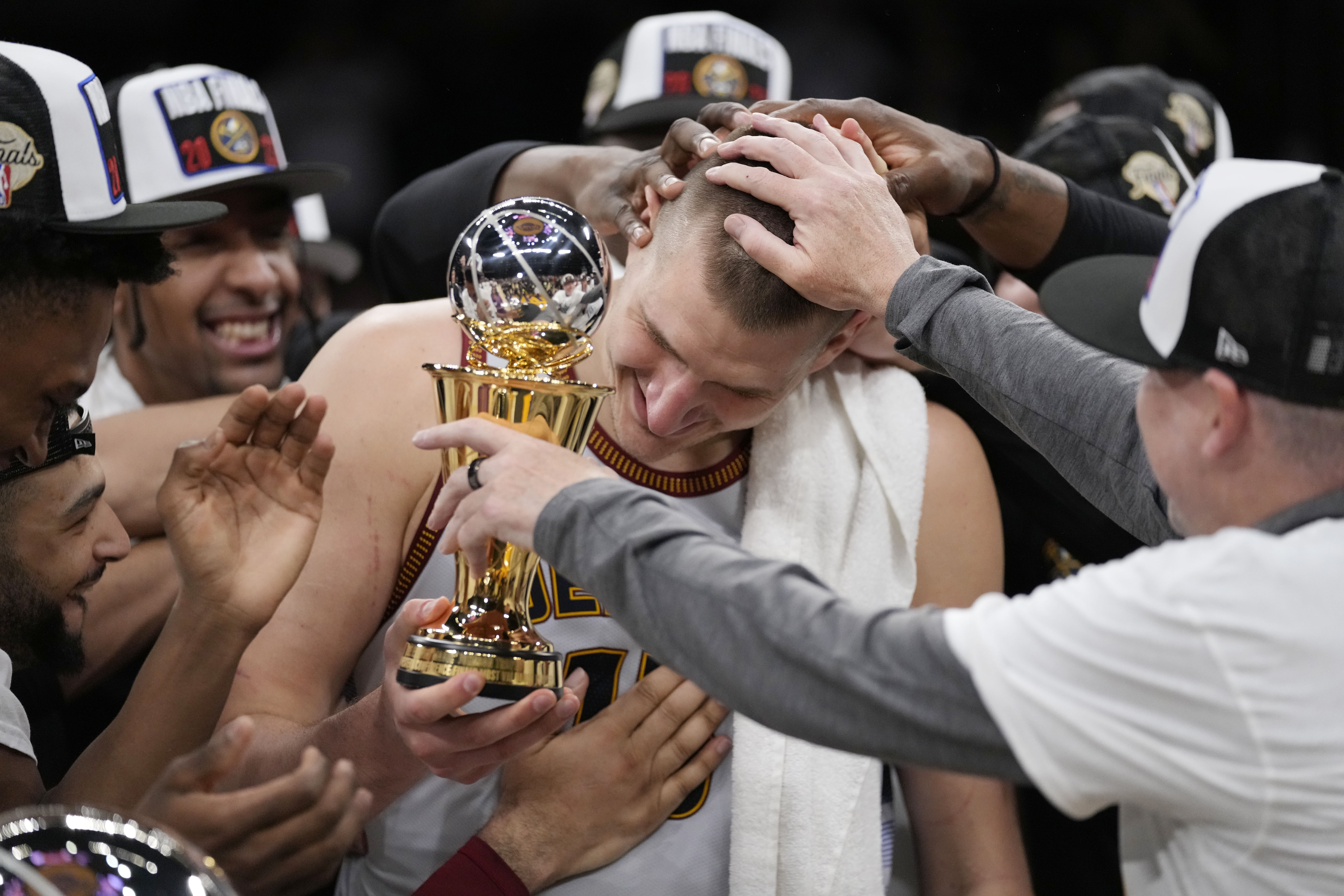 Denver Nuggets center Nikola Jokic is mobbed by teammates after accepting the series MVP trophy in after Game 4 of the NBA basketball Western Conference Final series Monday, May 22, 2023, in Los Angeles.