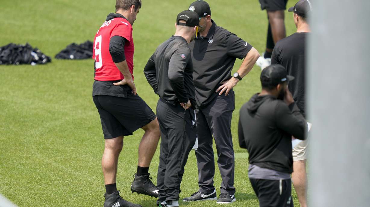 CORRECTS CITY AND STATE - New York Jets quarterback Aaron Rodgers (8) speaks with team personnel after performing weighted drills that led to favoring his lower legs at the NFL football team's practice facility, Tuesday, May 23, 2023, in Florham Park, N.J.