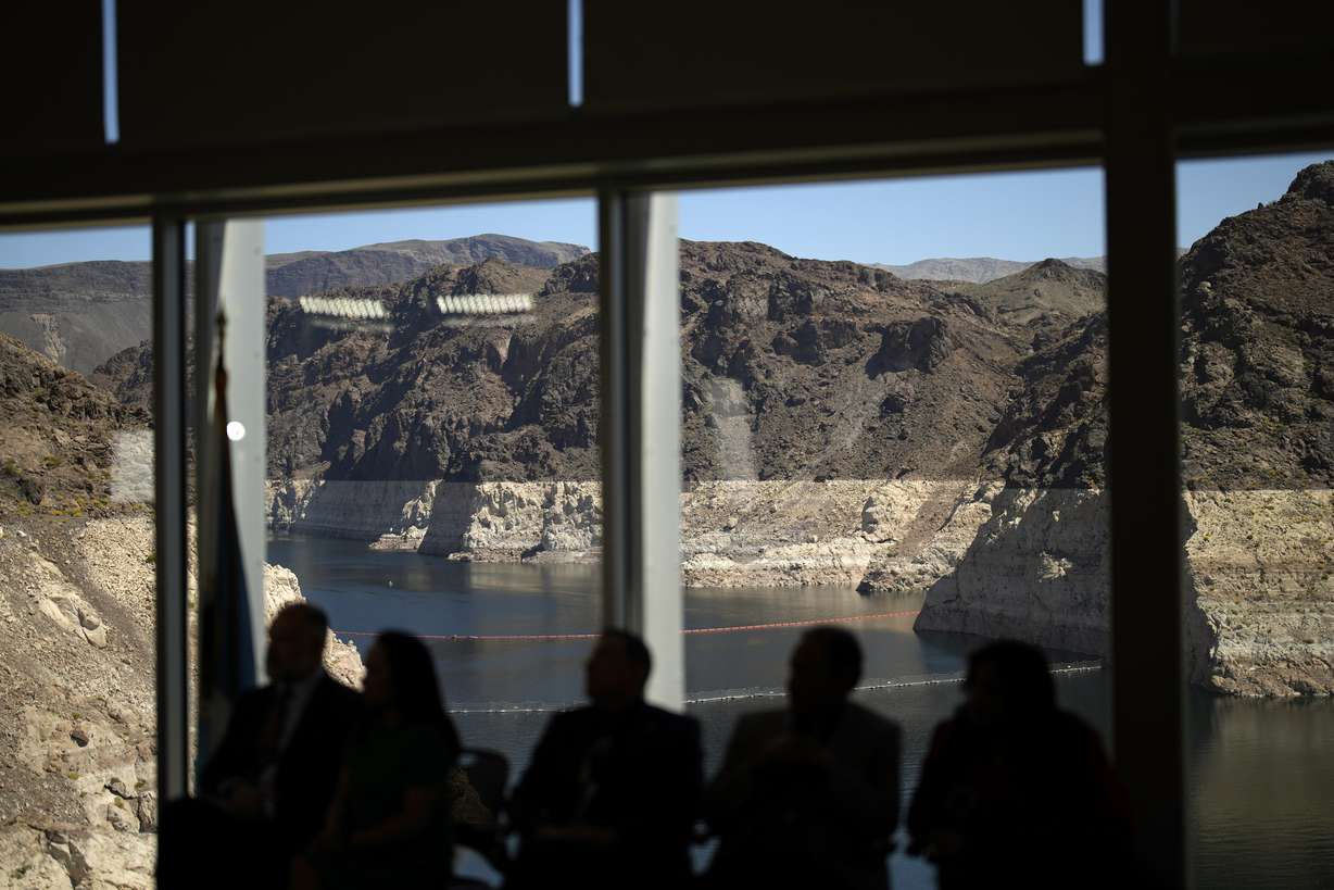 Officials listen during a news conference on Lake Mead at the Hoover Dam on April 11, 2023, near Boulder City, Nevada. The reservoir remains about 37% full.