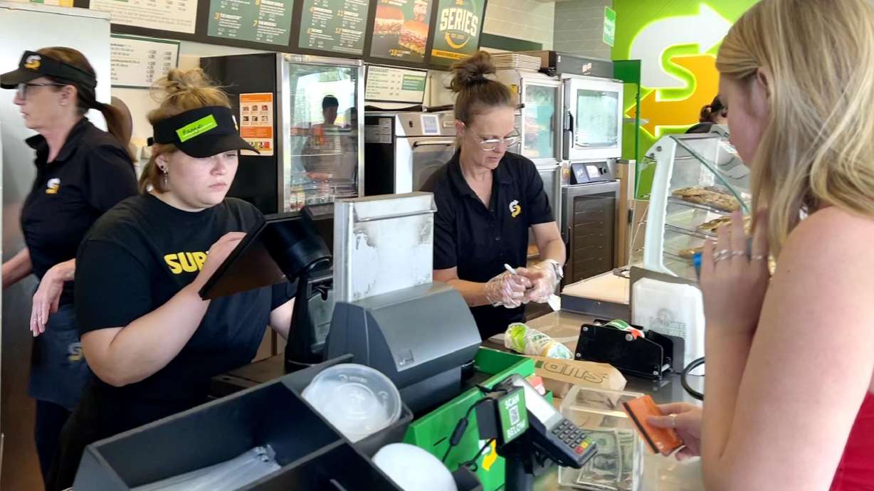 An employee, along with Kaysville Subway co-owner Jennifer Olsen, helps a customer during a "Senior Day" event Friday. Jennifer and Jordan Olsen donated all profits from Senior Day to their graduating employees.