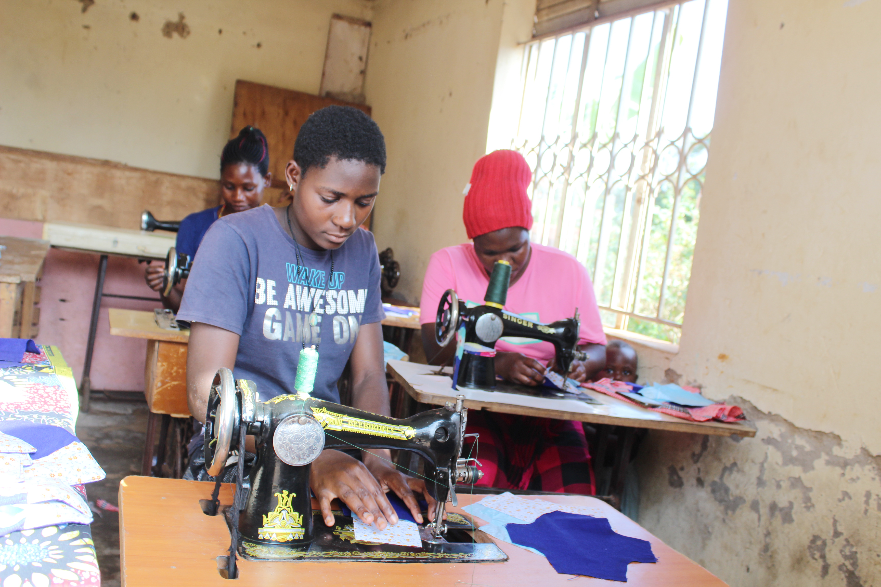 Women work on sewing machines at the Peace and Hope Training Center in Uganda in May. Olivia Sserabira, a Salt Lake City Walmart employee, uses her paycheck to fund the nonprofit she started in 2006.