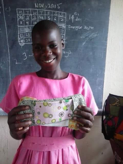 A young woman holds up a reusable pad that was given to her from the Peace and Hope Training Center in Uganda. Olivia Sserabira, a Salt Lake City Walmart employee, uses her paycheck, to fund the nonprofit she started in 2006.