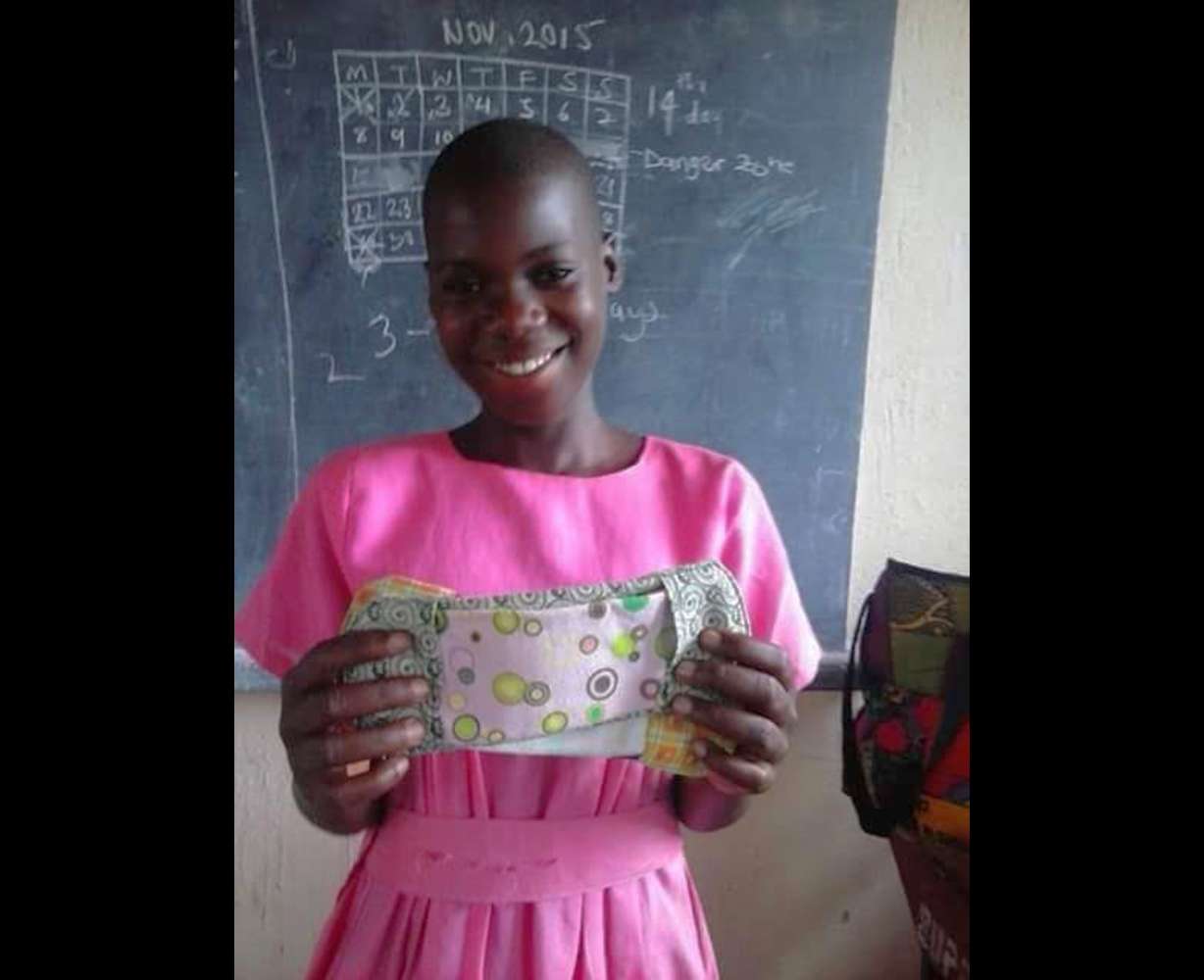 A young woman holds up a reusable pad that was given to her from the Peace and Hope Training Center in Uganda. Olivia Sserabira, a Salt Lake City Walmart employee, uses her paycheck, to fund the nonprofit she started in 2006.