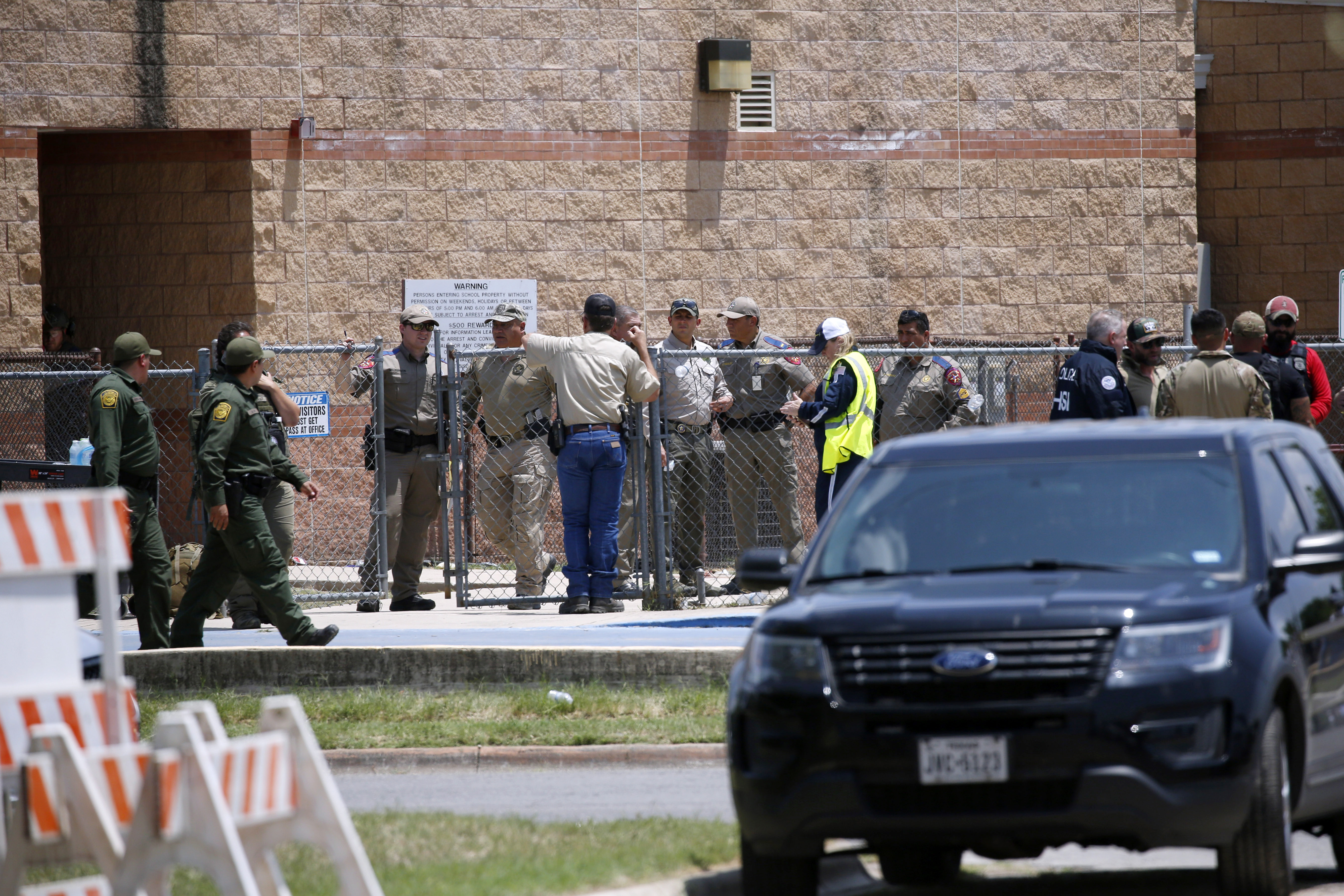 First responders gather outside Robb Elementary School following a shooting, May 24, 2022, in Uvalde, Texas. A criminal investigation in Texas over the hesitant police response remains ongoing a year after a gunman killed 19 children and two teachers.