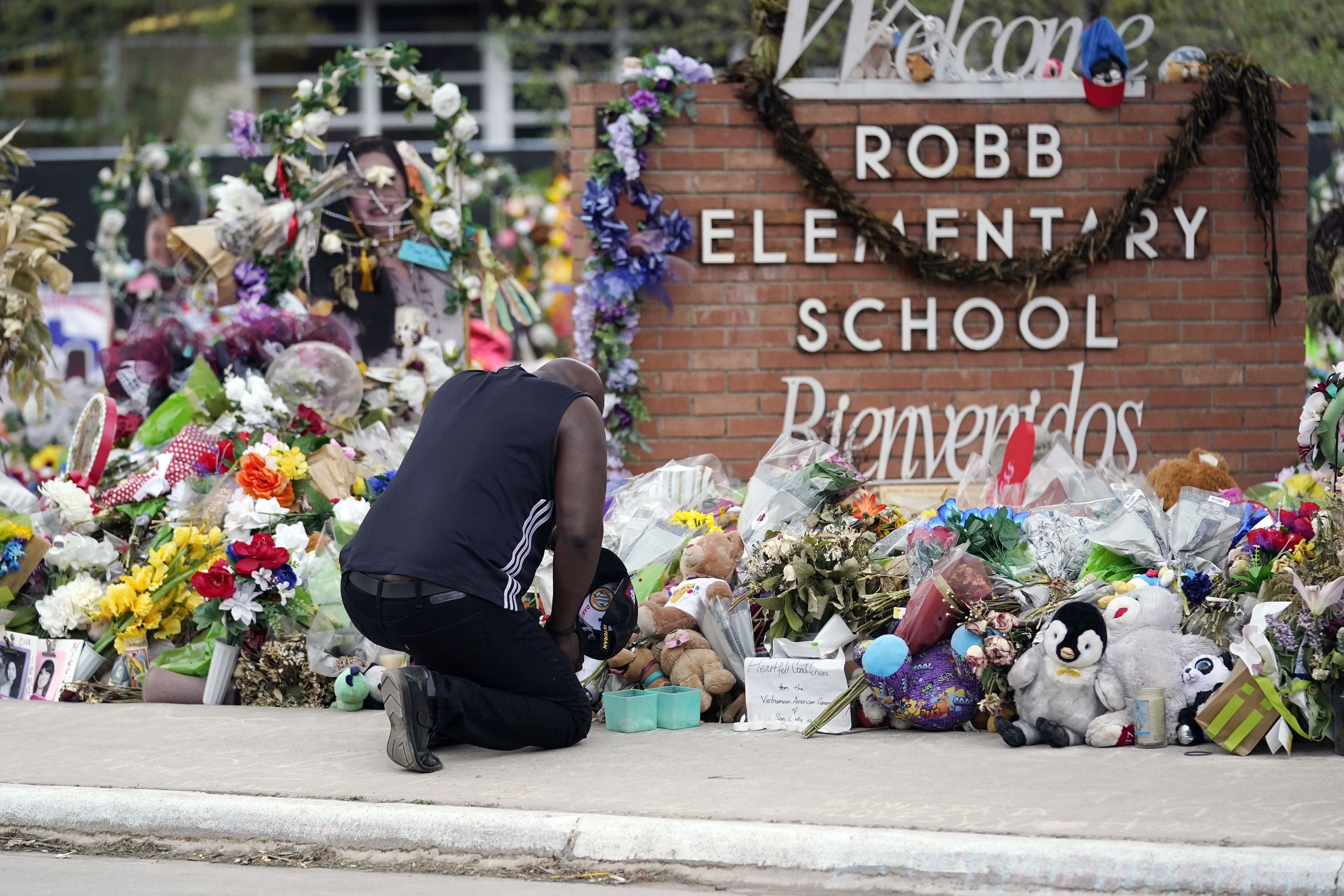 Reggie Daniels pays his respects at a memorial at Robb Elementary School, June 9, 2022, in Uvalde, Texas. A criminal investigation in Texas over the hesitant police response to a shooting at the school remains ongoing a year after a gunman killed 19 children and two teachers in Uvalde.