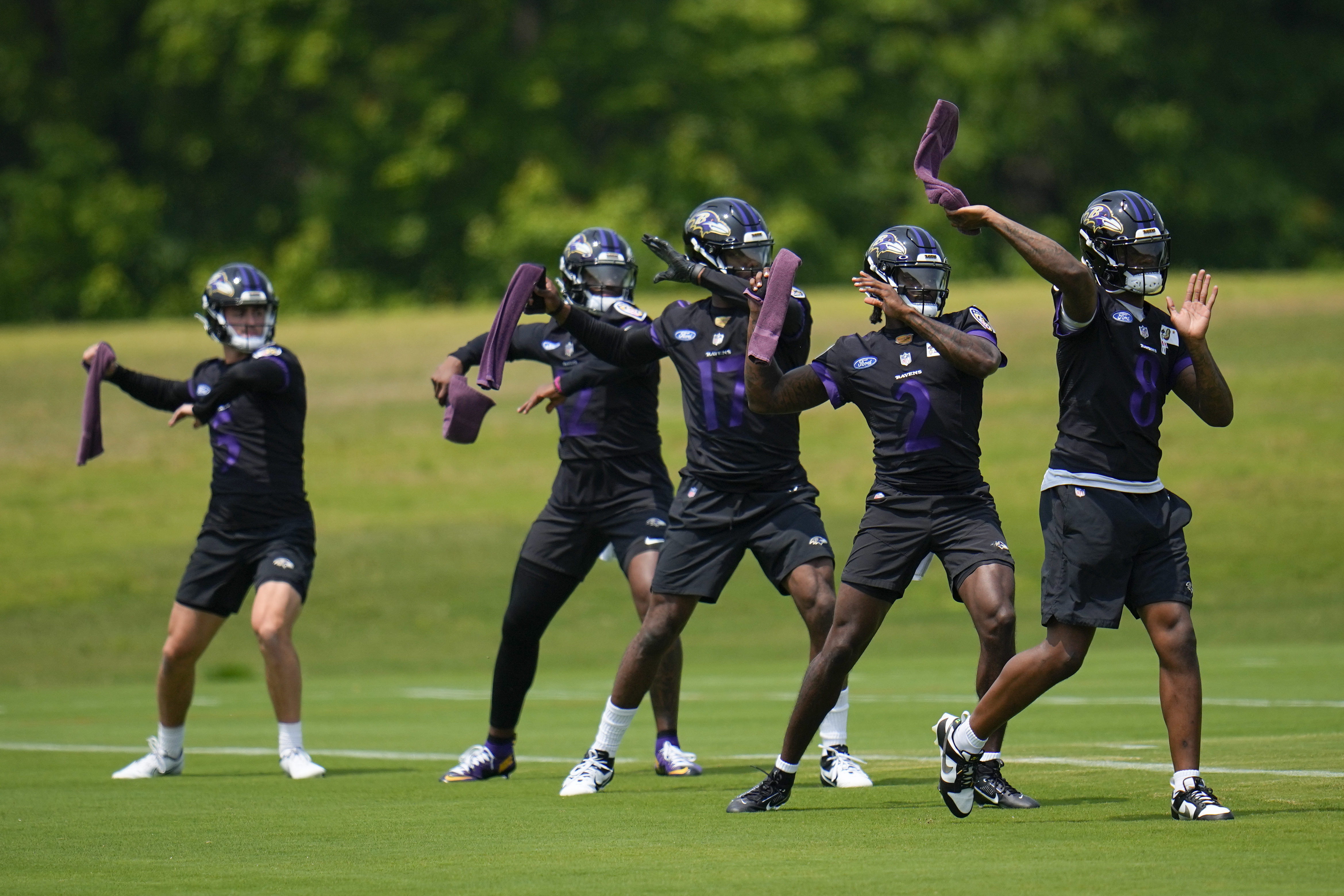 Baltimore Ravens quarterbacks, from left, Nolan Henderson, Anthony Brown, Josh Johnson, Tyler Huntley, and Lamar Jackson work out during the team's NFL football practice, Wednesday, May 24, 2023, in Owings Mills.