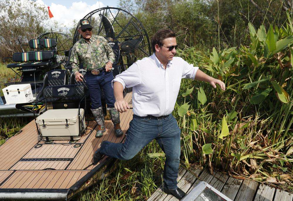 Then-Republican candidate for Florida Gov. Ron DeSantis, gets off an airboat with Gladesman and former Florida Fish and Wildlife Conservation commissioner Ron Bergeron after a tour of the Florida Everglades in Fort Lauderdale, Fla., Sept. 12, 2018.