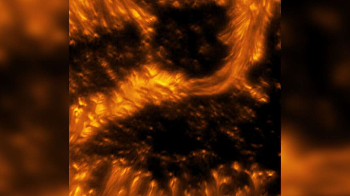 A light bridge can be seen spanning across a dark sunspot on the sun.