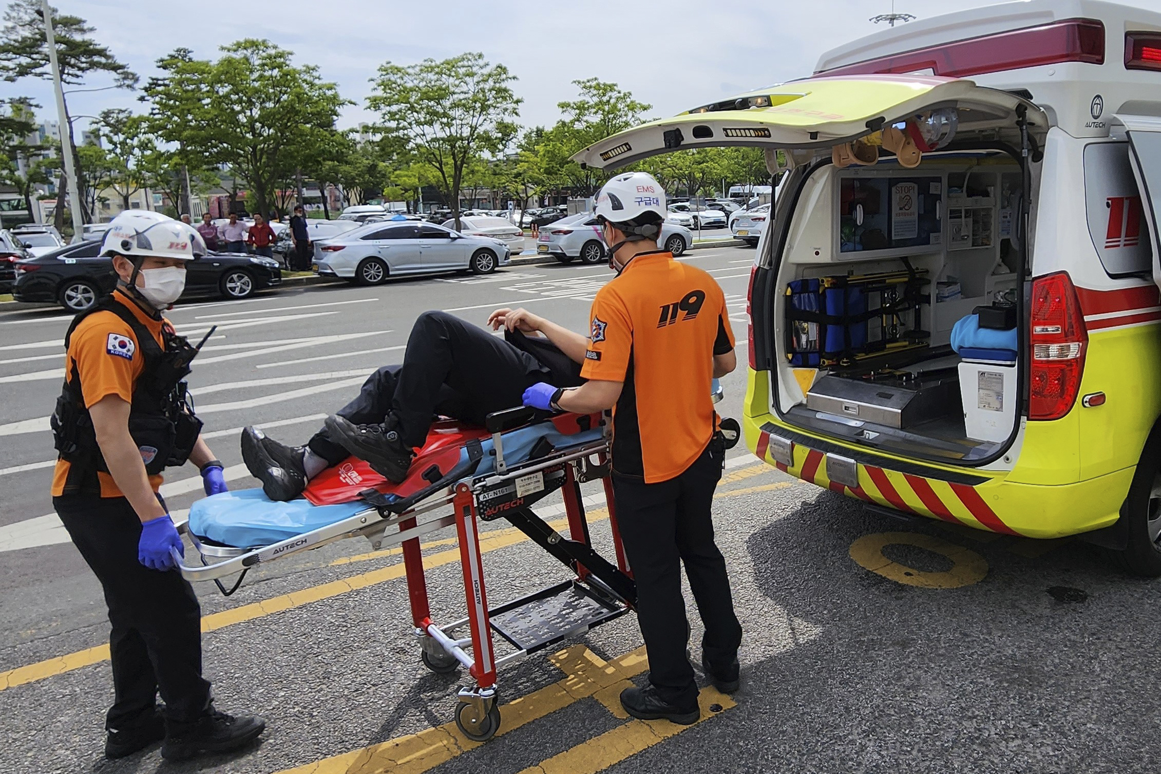 Rescue workers move a passenger on a stretcher to an ambulance at Daegu International Airport in Daegu, South Korea, Friday. A passenger opened a door on an Asiana Airlines flight that later landed safely at a South Korean airport Friday, airline and government officials said.