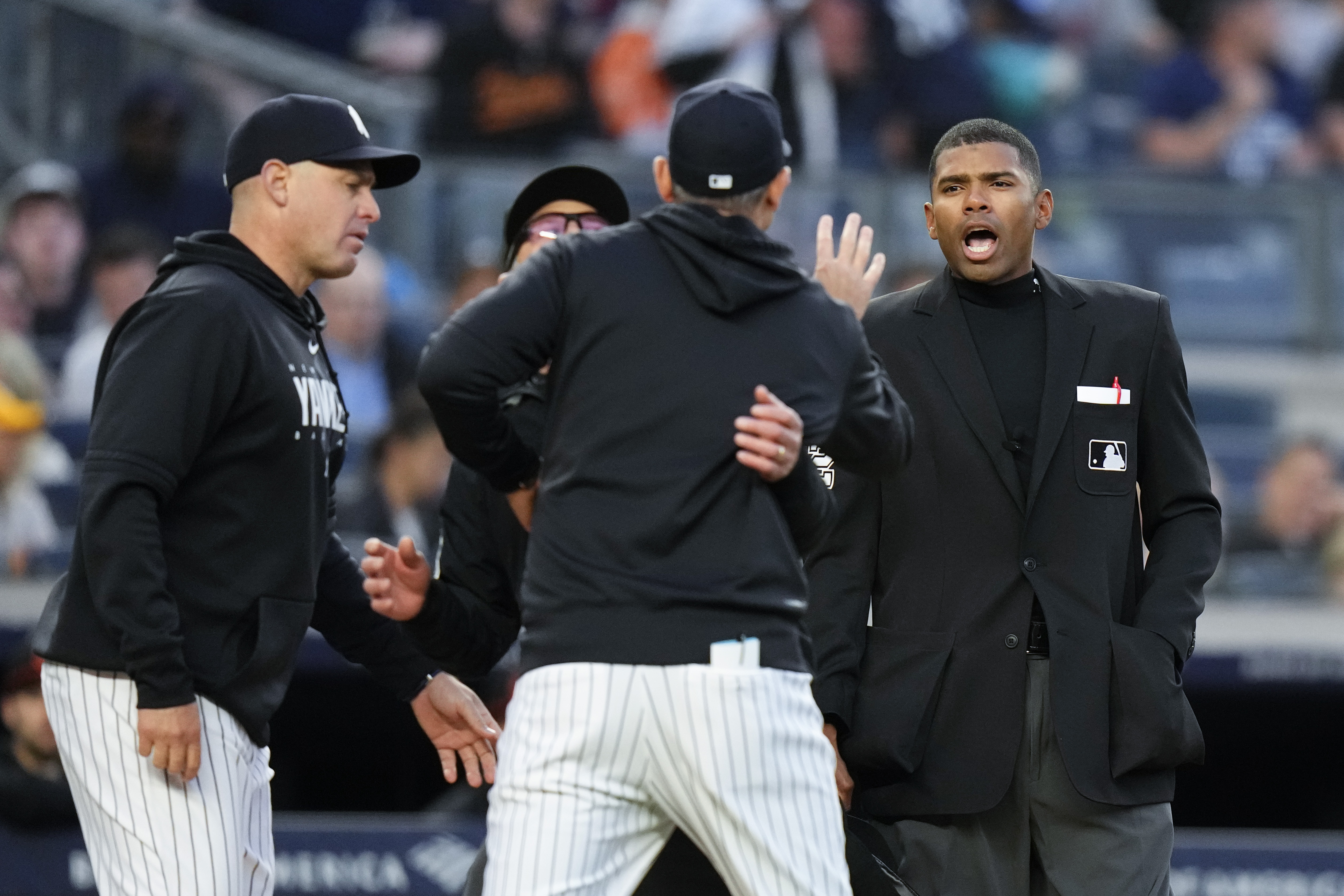 Home plate umpire Edwin Moscoso, right, talks to New York Yankees manager Aaron Boone as Boone is restrained after being ejected during the third inning of the team's baseball game against the Baltimore Orioles on Thursday, May 25, 2023, in New York. 