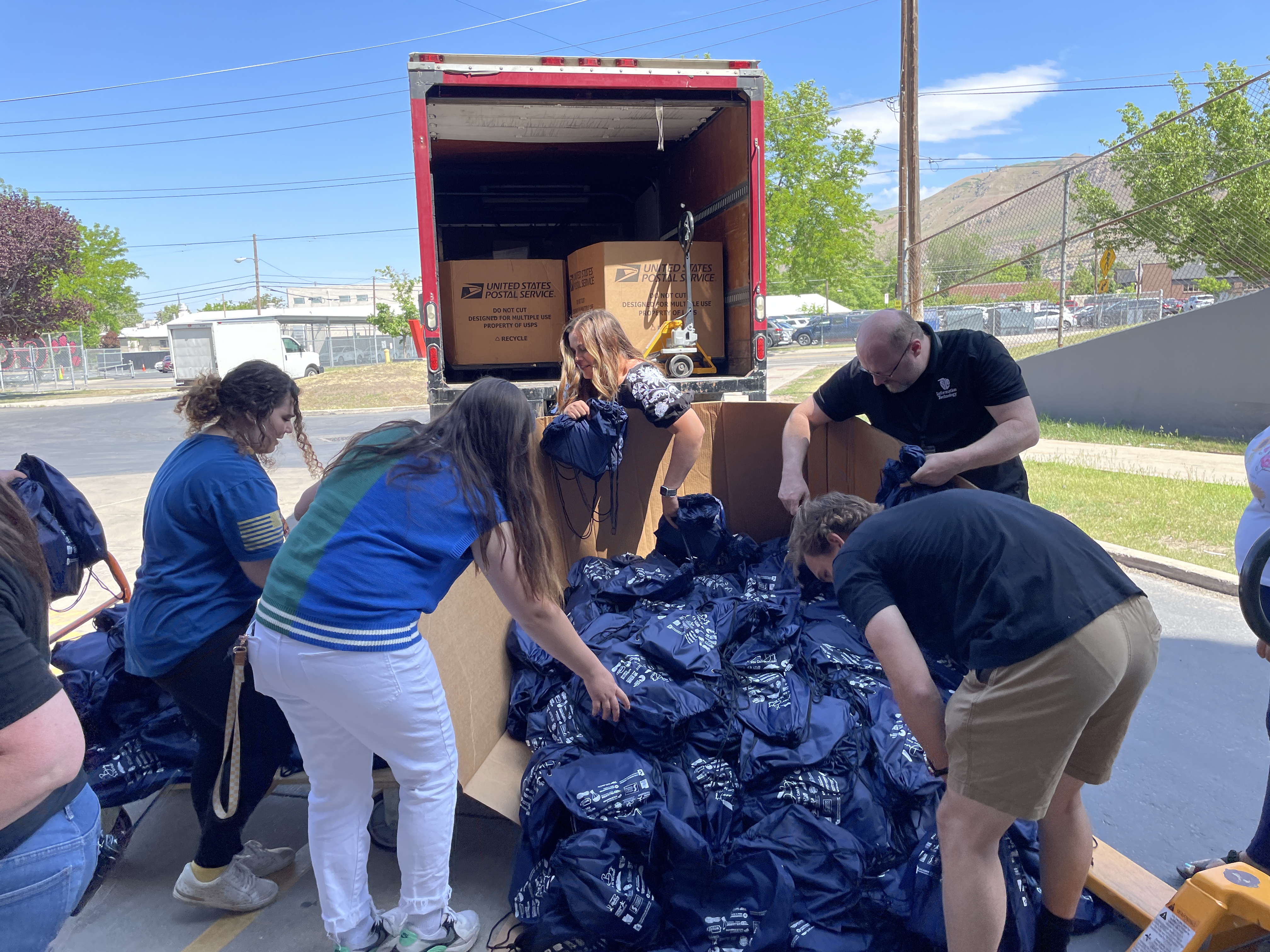 The Teen Author Boot Camp staff helps unload the books and place them into bags for the Dream Big Project on Tuesday.