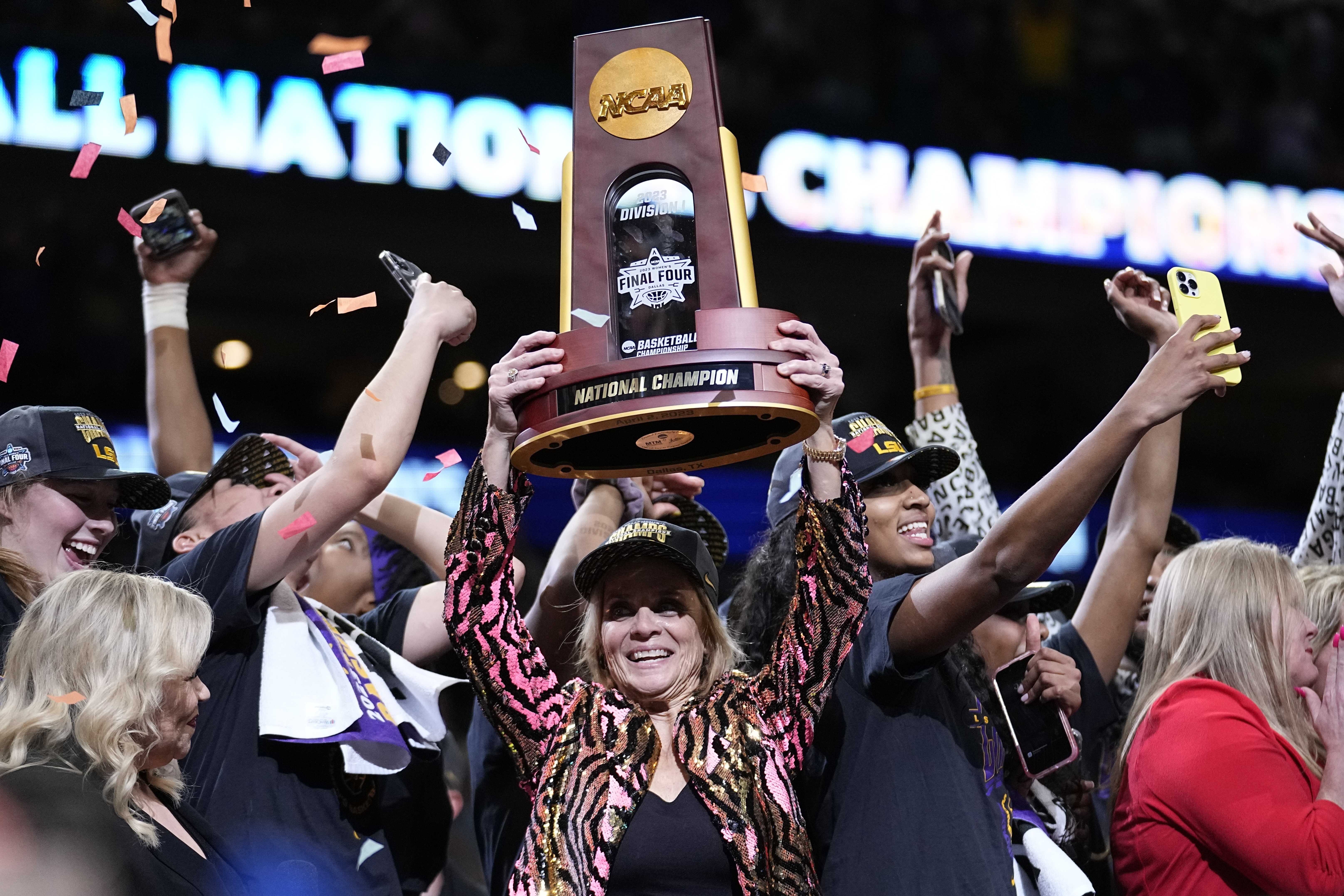 FILE - LSU head coach Kim Mulkey holds the winning trophy after the NCAA Women's Final Four championship basketball game against Iowa Sunday, April 2, 2023, in Dallas. LSU won 102-85 to win the championship. 