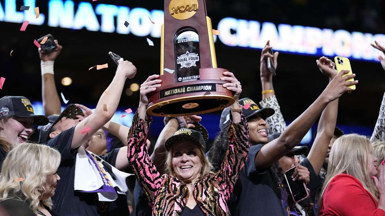 FILE - LSU head coach Kim Mulkey holds the winning trophy after the NCAA Women's Final Four championship basketball game against Iowa Sunday, April 2, 2023, in Dallas. LSU won 102-85 to win the championship.