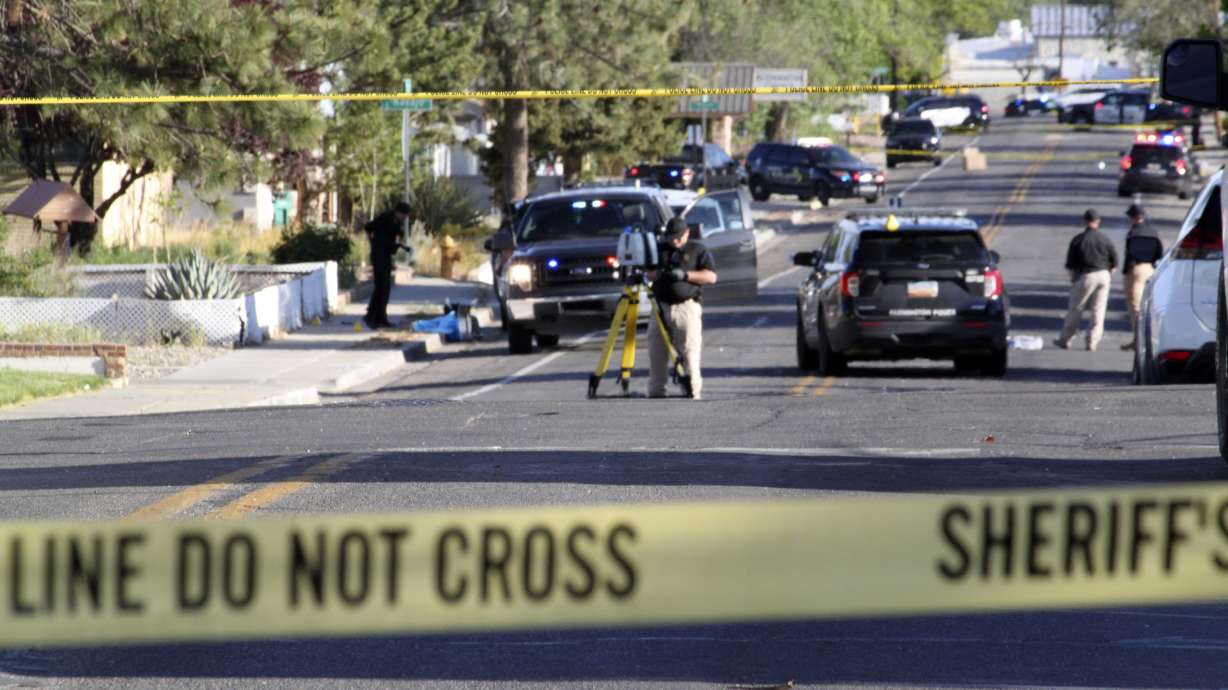 Investigators work along a residential street following a deadly shooting, May 15, in Farmington, N.M. Police released hours of videos and 911 recordings showing the chaos that unfolded when the gunman opened fire, killing three.