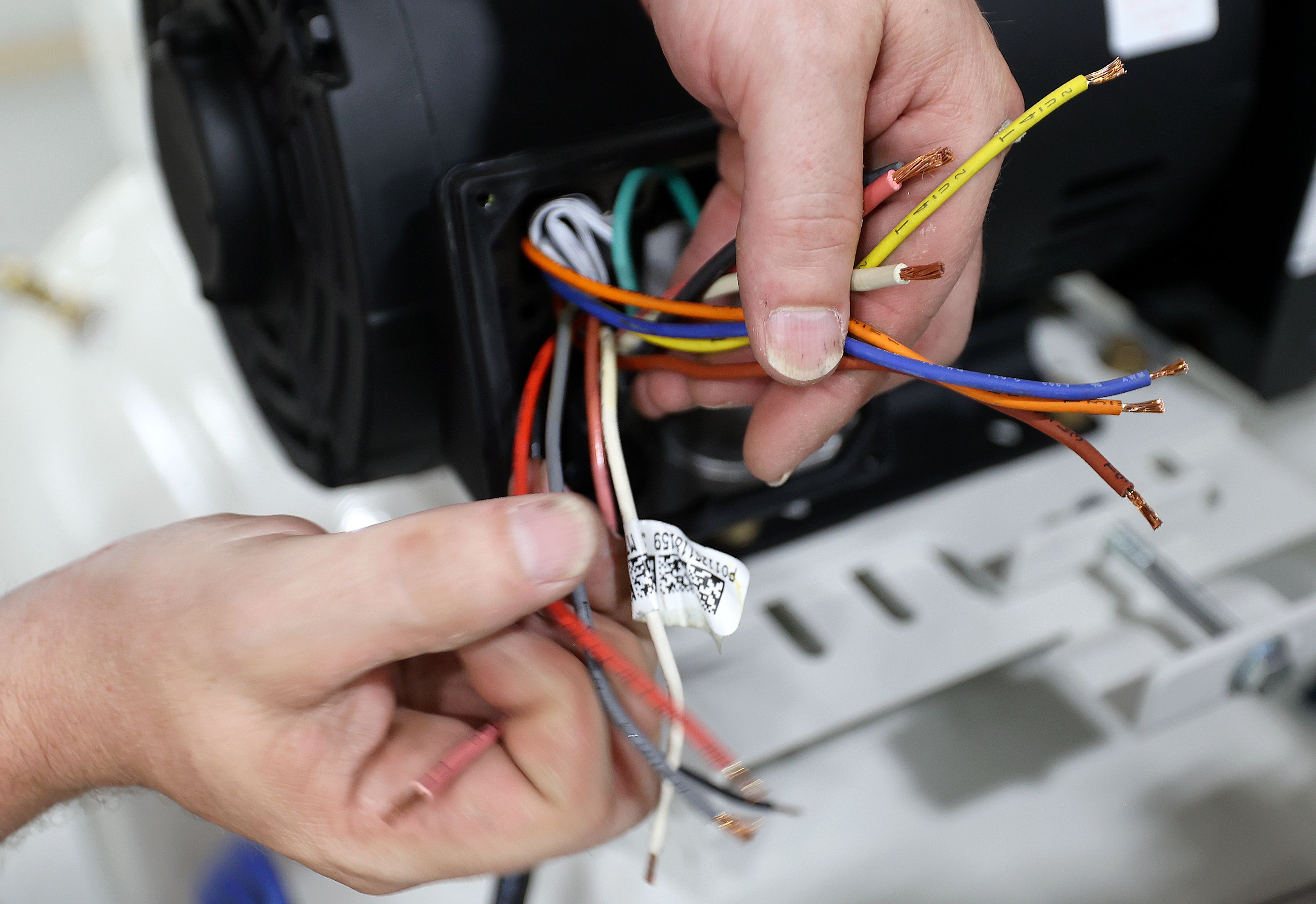 Qnergy production associate Adam Wright wires compressors on a Powerex tank at Qnergy in Ogden on Thursday.