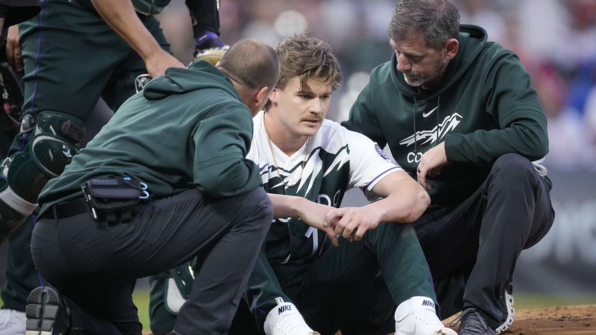 Trainers tend to Colorado Rockies starting pitcher Ryan Feltner after he was hit by a batted ball from Philadelphia Phillies' Nick Castellanos, who singled during the second inning of a baseball game Saturday, May 13, 2023, in Denver.