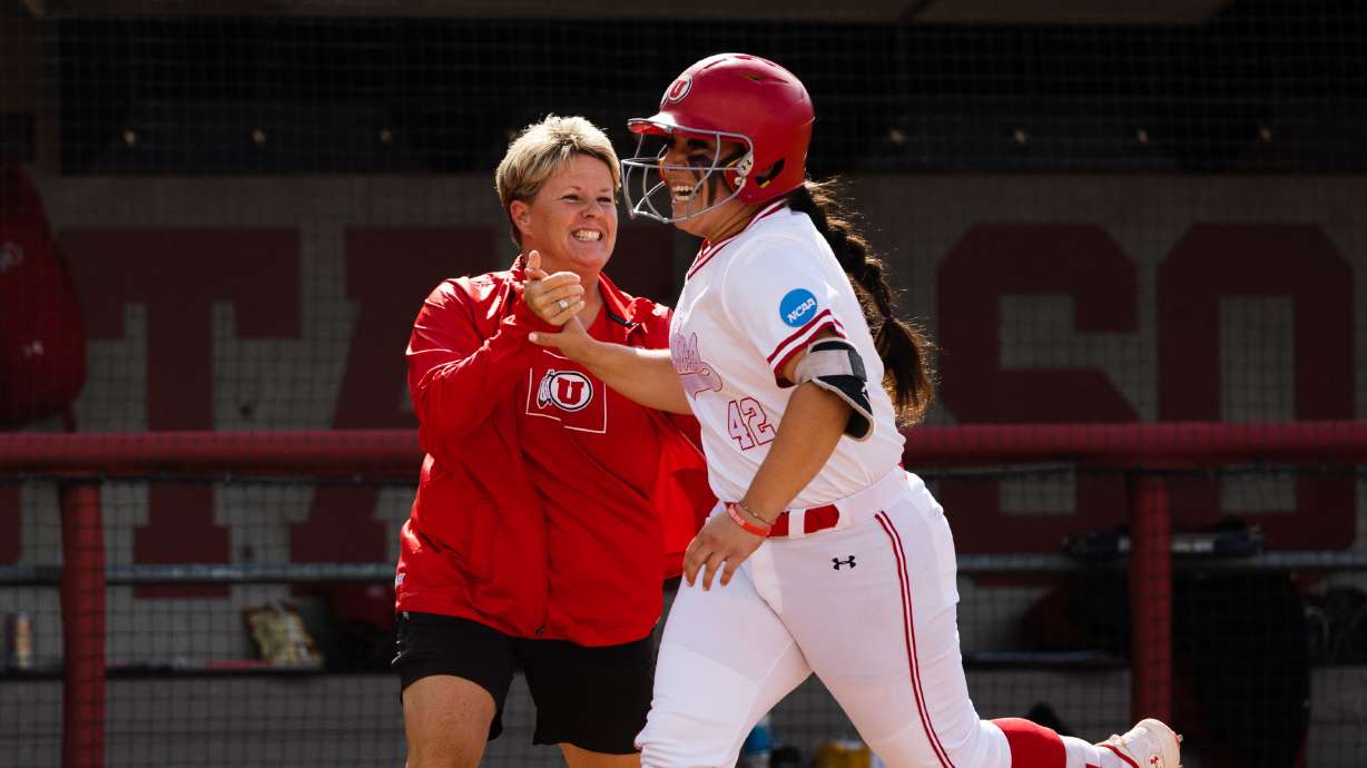Utah infielder Julia Jimenez (42) high-fives Utah head coach Amy Hogue after a home run during the second game of the NCAA softball Super Regional between Utah and San Diego State at Dumke Family Softball Stadium in Salt Lake City on May 27, 2023.