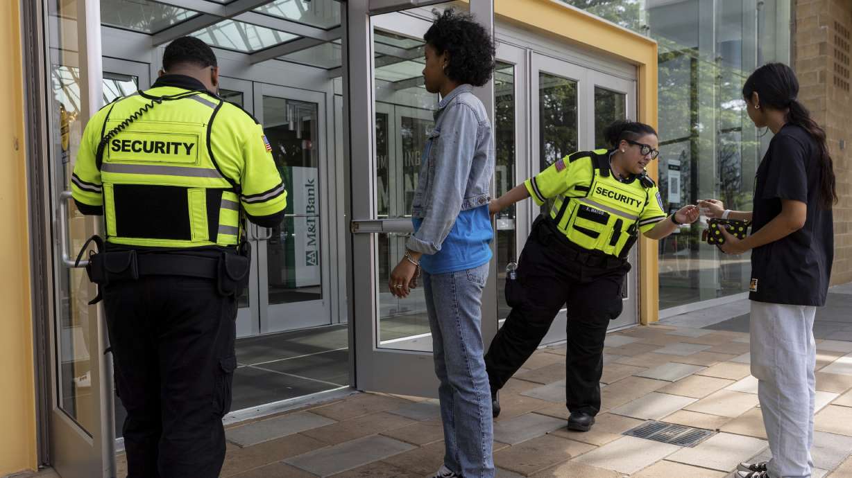Security guards check identification for proof of age outside the Mall on May 12 in Columbia, Md. The mall has a police that requires all visitors under 18 be accompanied by an adult who is at least 21 after 4 p.m. on Fridays and Saturdays.