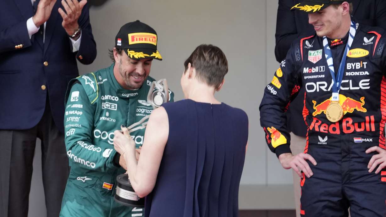 Aston Martin driver Fernando Alonso of Spain, left, is presented his second place trophy by Monaco's Princess Charlene during the Monaco Formula One Grand Prix, at the Monaco racetrack, in Monaco, Sunday, May 28, 2023.