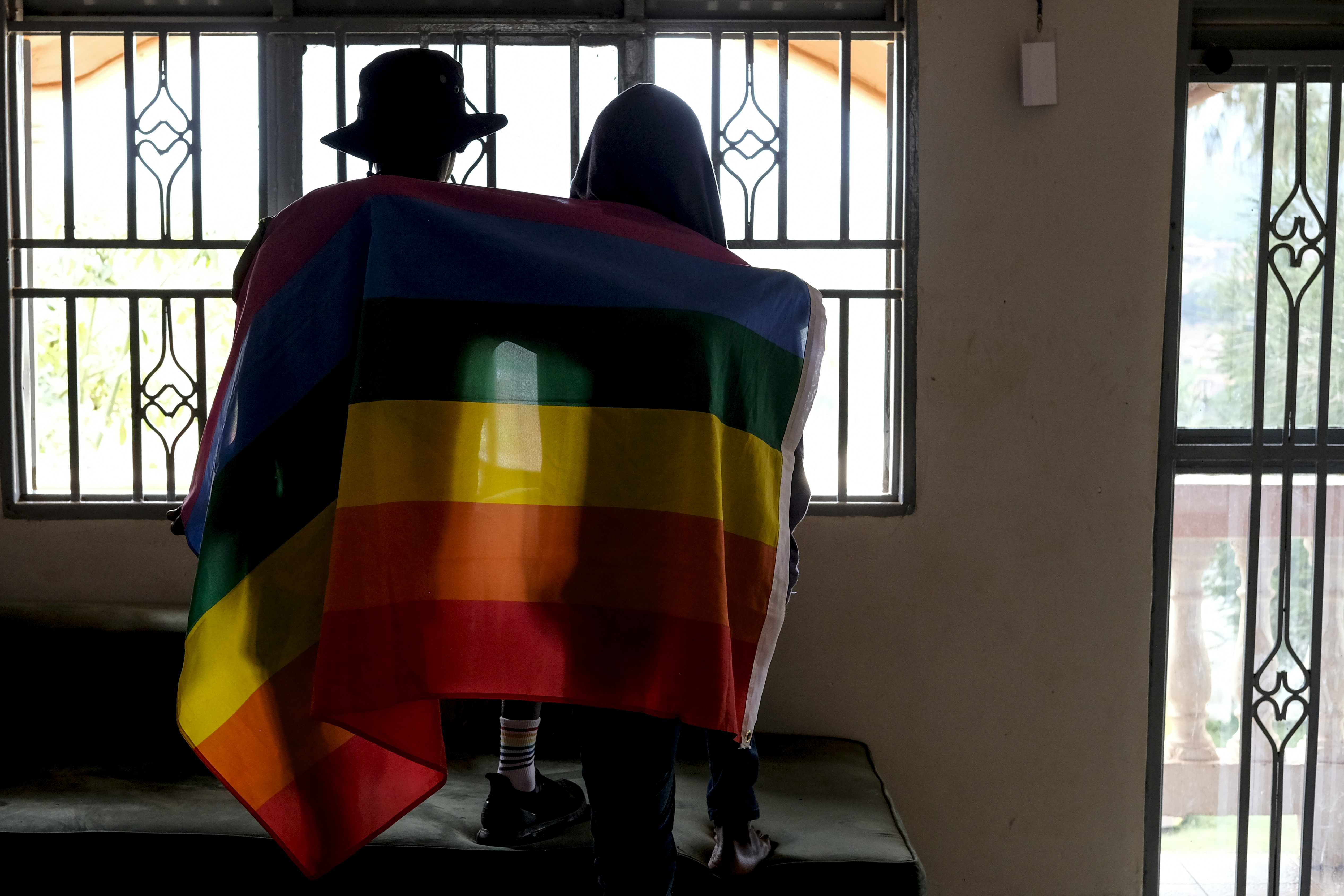 A gay Ugandan couple cover themselves with a pride flag as they pose for a photograph in Uganda on March 25. Uganda's president Yoweri Museveni signed into law tough new anti-gay legislation supported by many in the country but widely condemned by rights activists and others abroad.