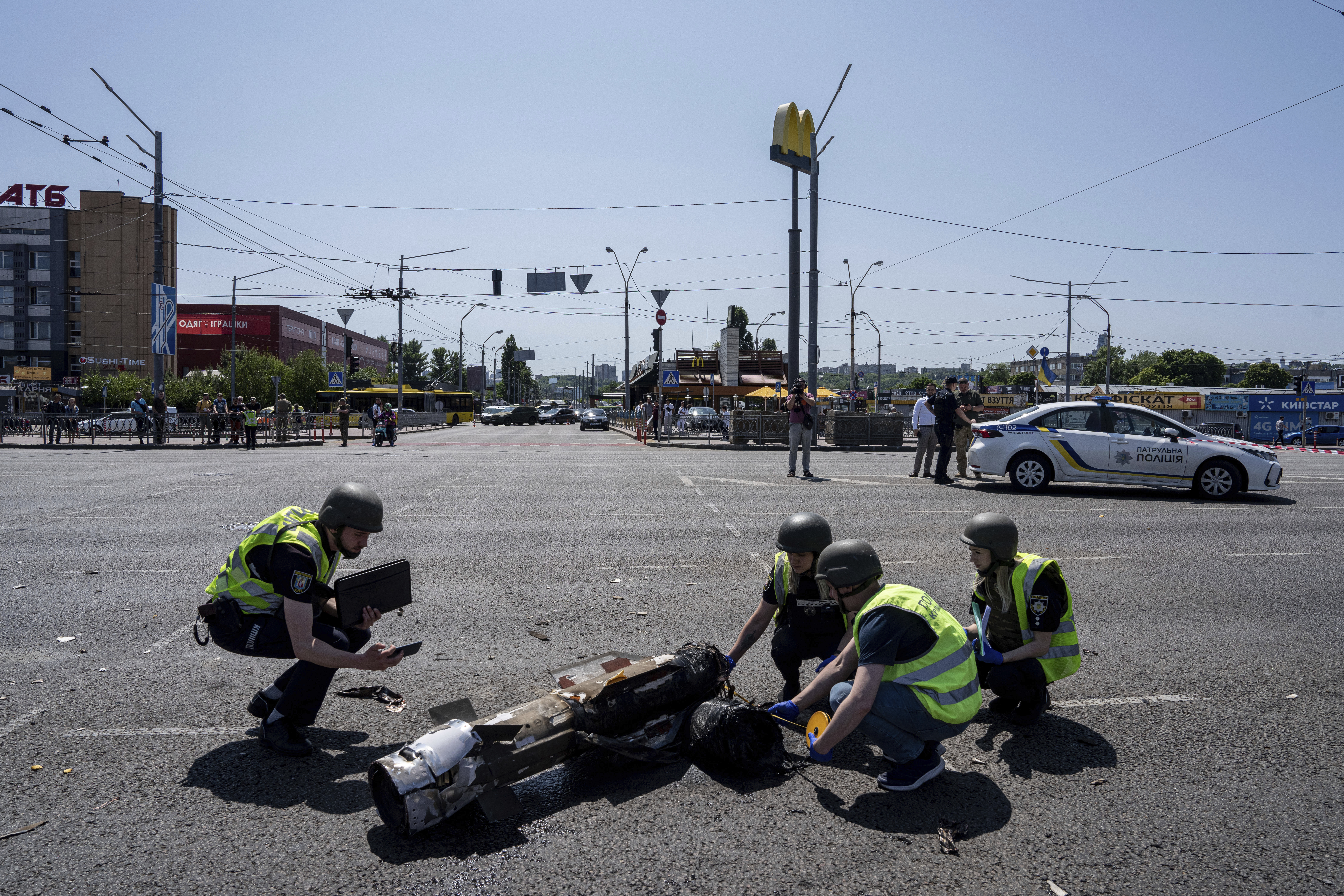 Ukrainian Police officers inspecting a fragment of the rocket after a Russian rocket attack in Kyiv, Ukraine, Monday. Explosions rattled Kyiv during daylight hours after a more common nighttime attack of the city by drones and cruise missiles.