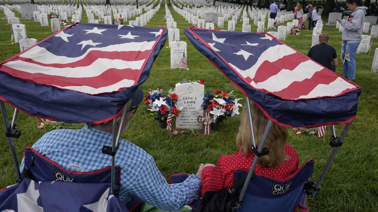 Eugene and Linda Lamie, of Homerville, Ga., sit by the grave of their son U.S. Army Sgt. Gene Lamie in Section 60 at Arlington National Cemetery on Memorial Day, Monday, in Arlington, Virginia.