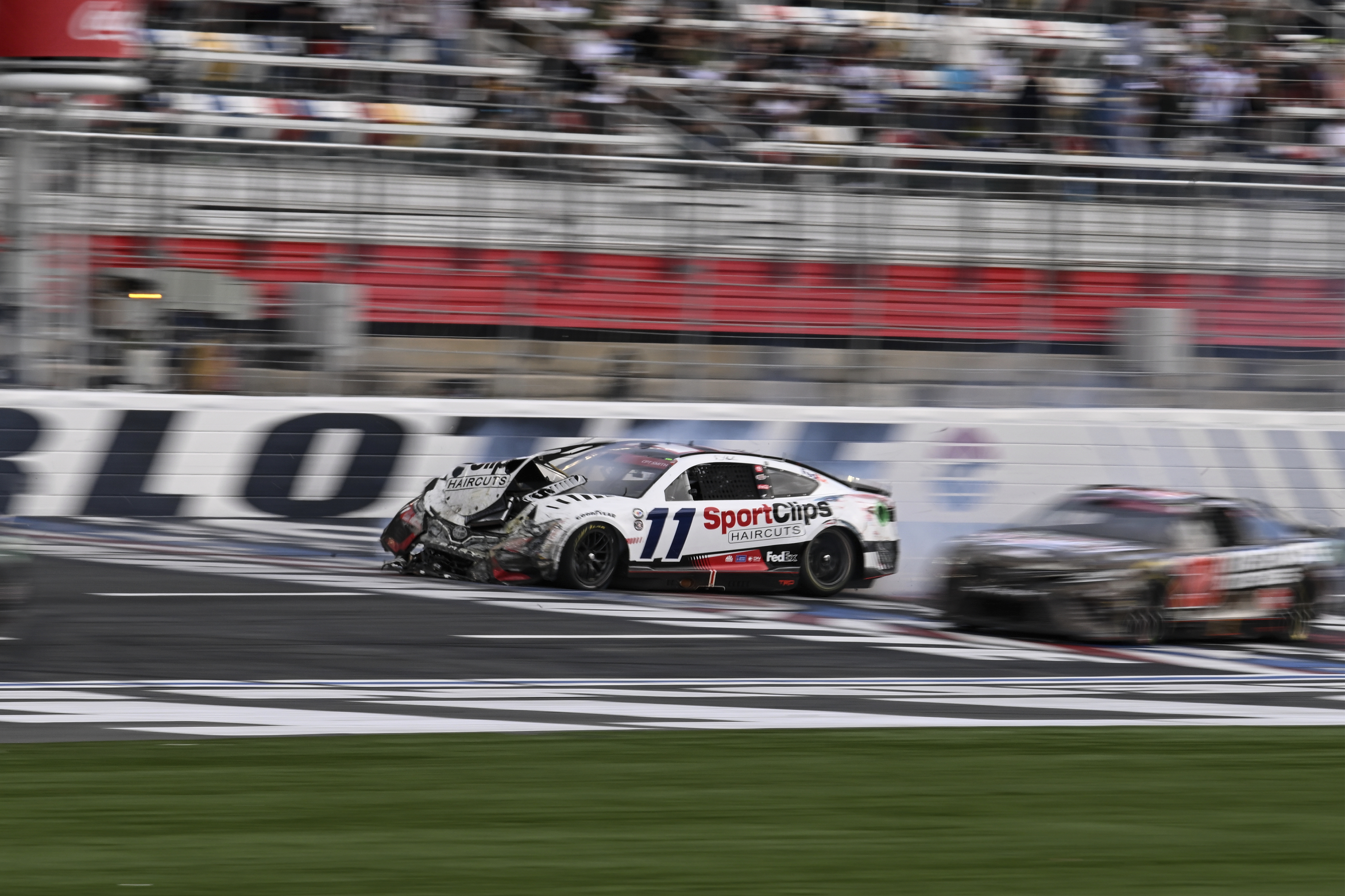 Denny Hamlin (11) crashes on the front stretch during a NASCAR Cup Series auto race at Charlotte Motor Speedway, Monday, May 29, 2023, in Concord, N.C.