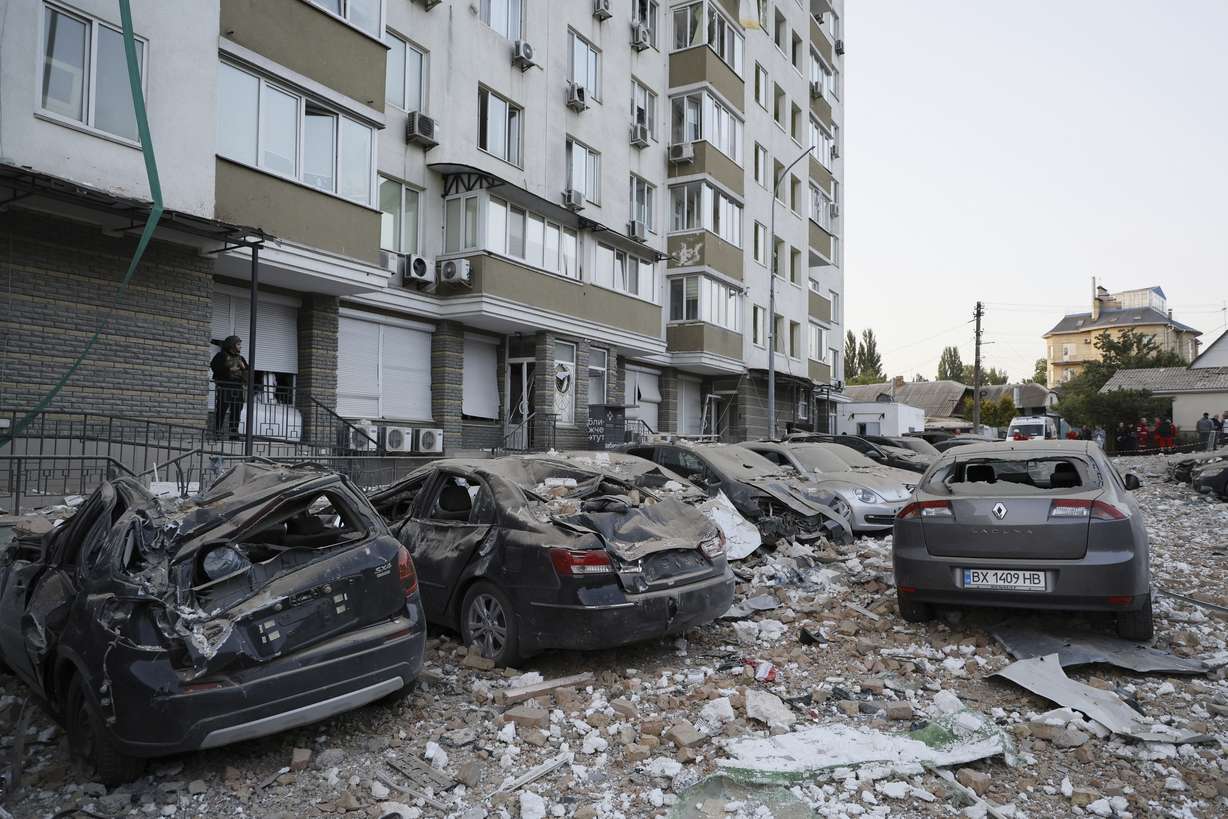 Damaged cars are parked in the yard of a multi-story apartment building damaged in a relentless wave of bombardments targeting Kyiv, Ukraine, Tuesday.
