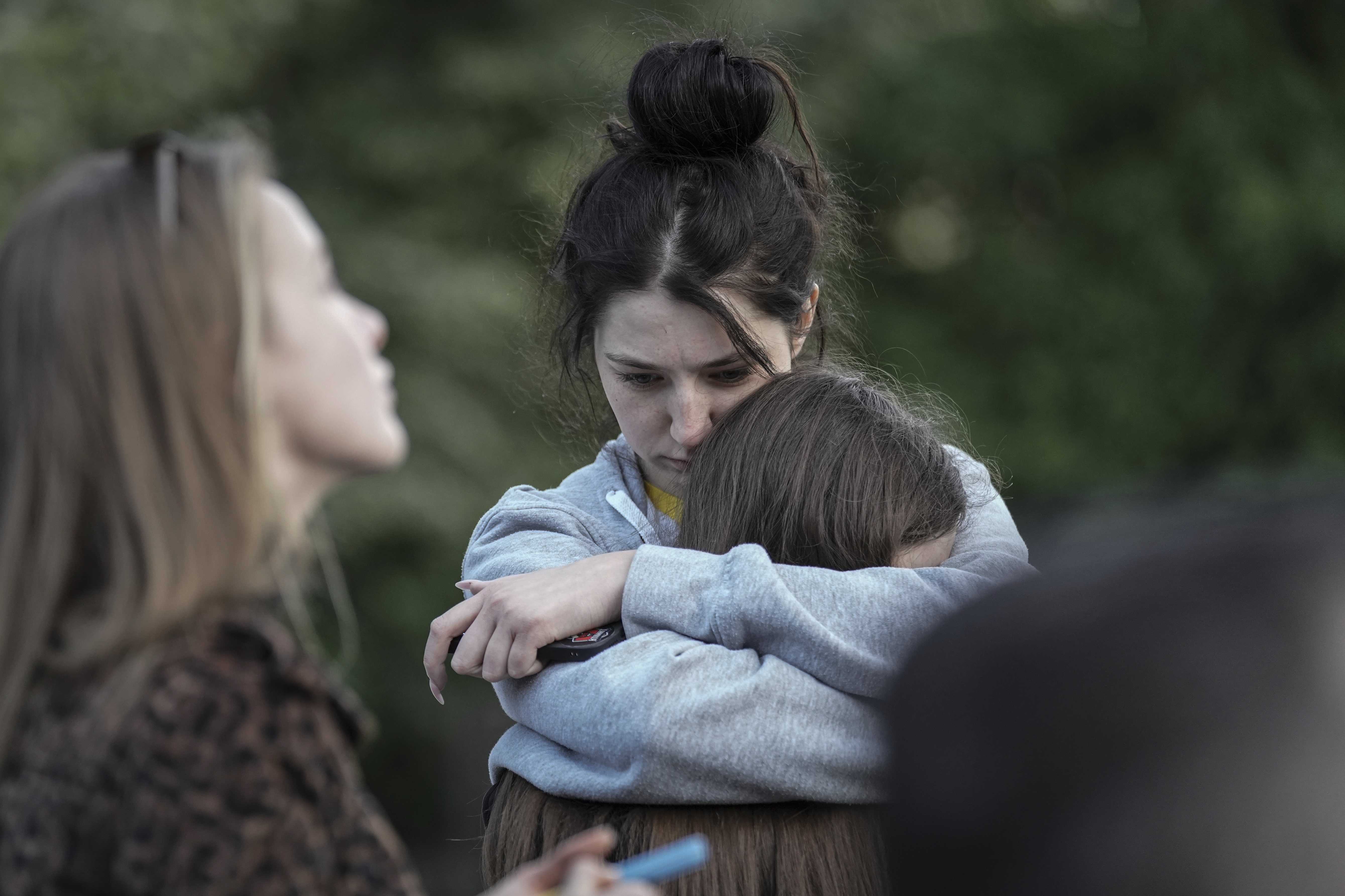 Evacuated residents hug outside of their multi-story apartment building damaged during a Russian attack in Kyiv, Ukraine, Tuesday.