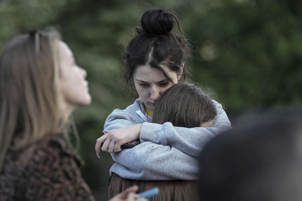 Evacuated residents hug outside of their multi-story apartment building damaged during a Russian attack in Kyiv, Ukraine, Tuesday.