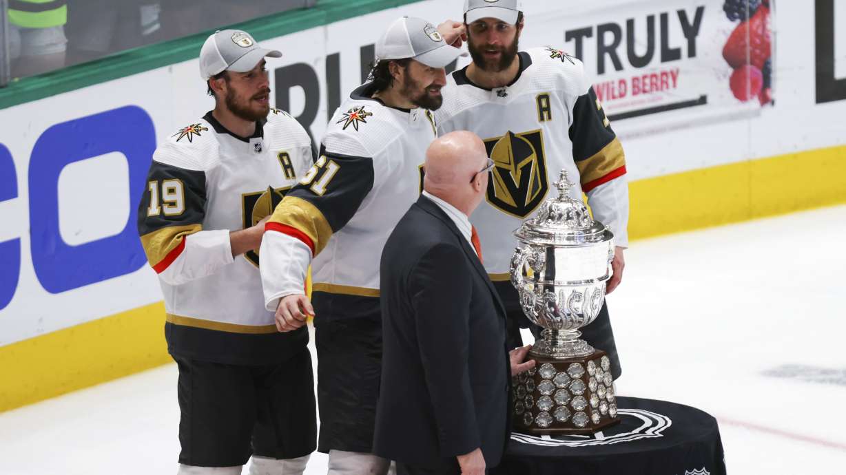 Vegas Golden Knights players Reilly Smith, left, Mark Stone, back center, and Alex Pietrangelo pose with deputy commissioner of the NHL Bill Daly, front, after winning Game 6 of the NHL hockey Stanley Cup Western Conference finals against the Dallas Stars, Monday, May 29, 2023, in Dallas.