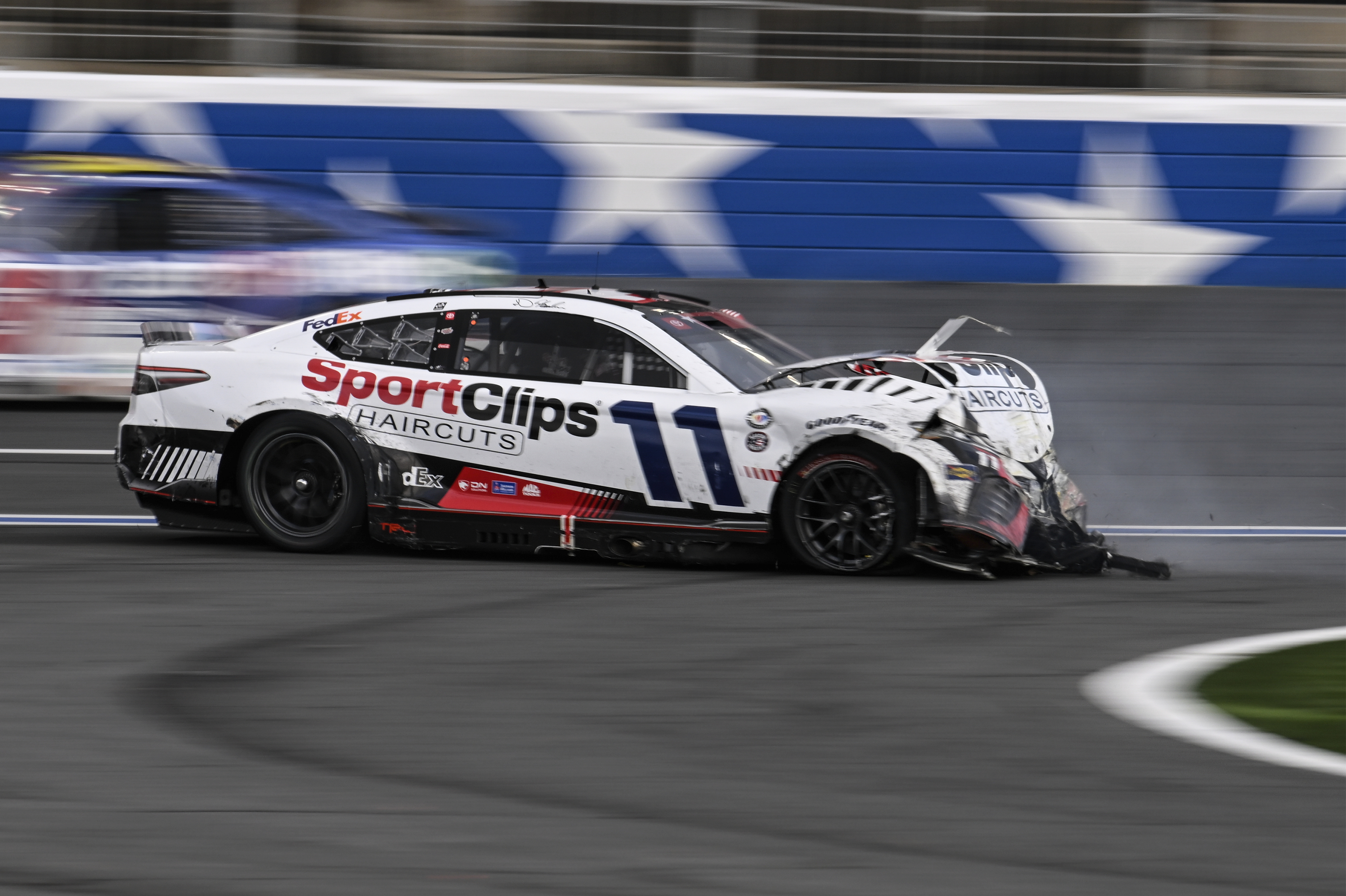 Denny Hamlin (11) crashes on the front stretch during a NASCAR Cup Series auto race at Charlotte Motor Speedway, Monday, May 29, 2023, in Concord, N.C.