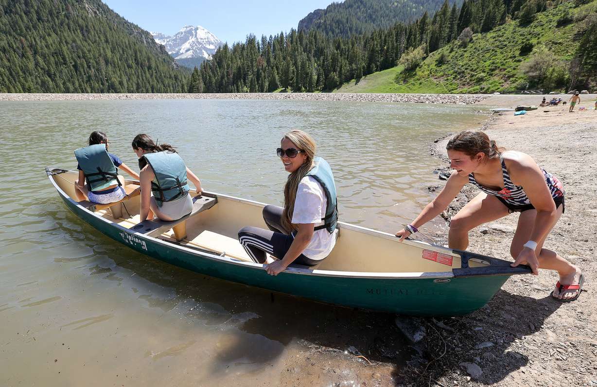 From right, Kaylee Harding gives Lori Lowe, Lilly Betenson and Sophia Rosenlof a push as they canoe on Tibble Fork Reservoir in American Fork Canyon on Tuesday.