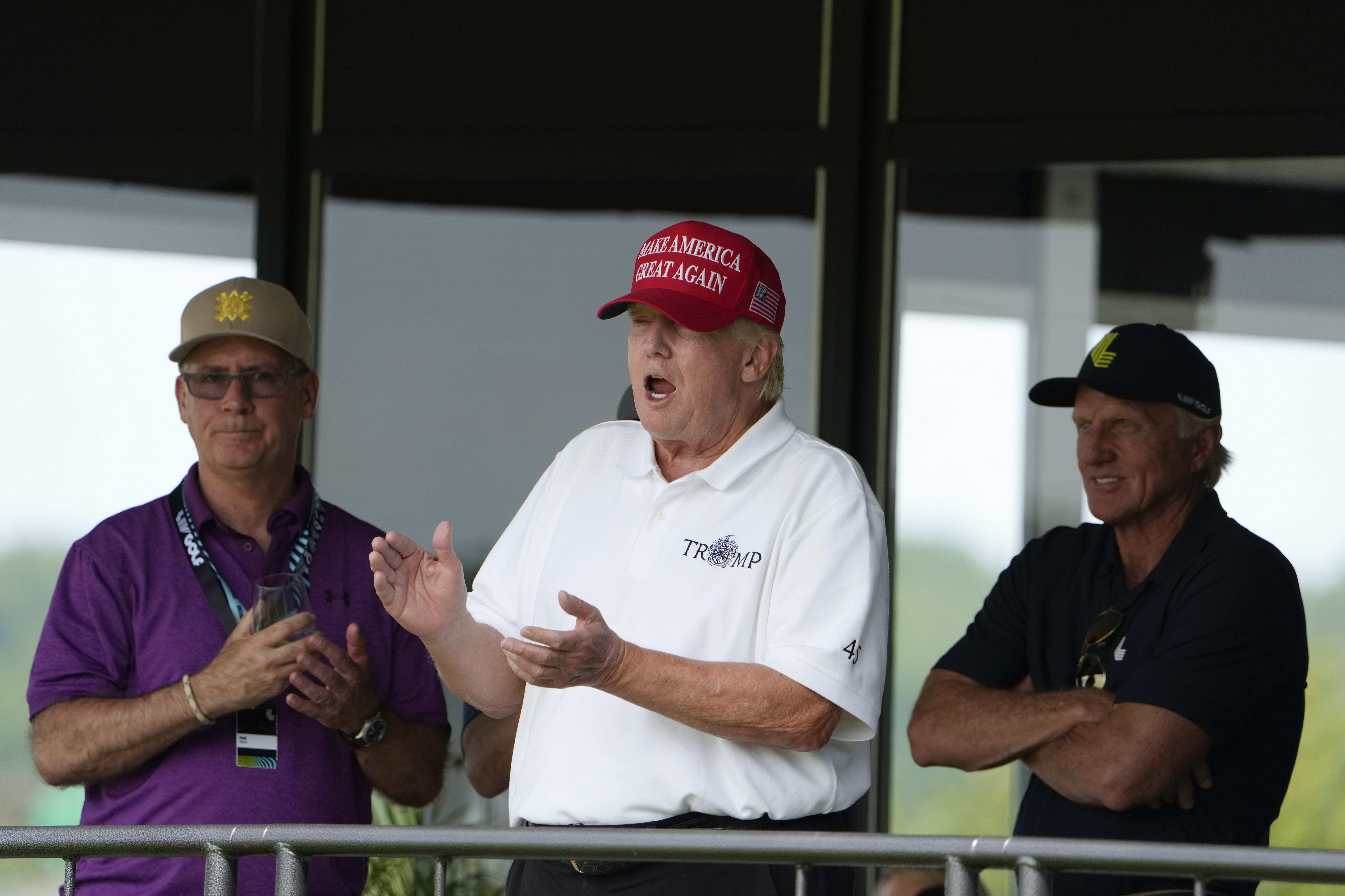 Former President Donald Trump, Greg Norman, LIV Golf CEO and Paul Myler, deputy head of mission for the Australian Embassy in Washington watch the LIV Golf Saturday in Sterling, Va. Reports say Justice Department prosecutors have an audio recording of Trump, in which he talks about holding onto a classified document.