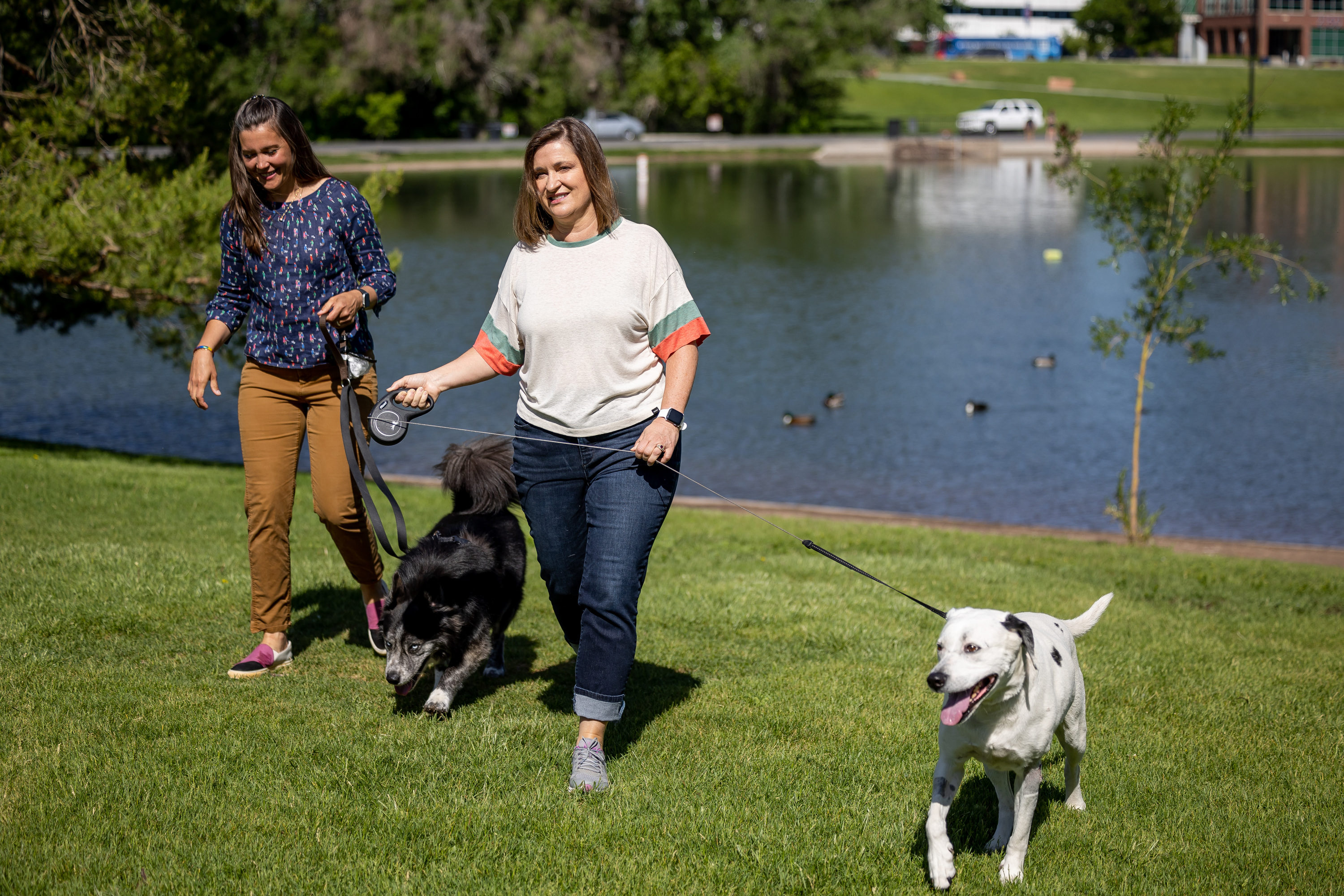 Salt Lake City Mayor Erin Mendenhall, left, and her dog Jack, and Salt Lake County Mayor Jenny Wilson and her dog Puddles, came together for a press conference on water safety at Sugar House Park in Salt Lake City on Thursday. Officials are warning people and their pets to stay clear of rivers and creeks swollen by spring snowmelt.