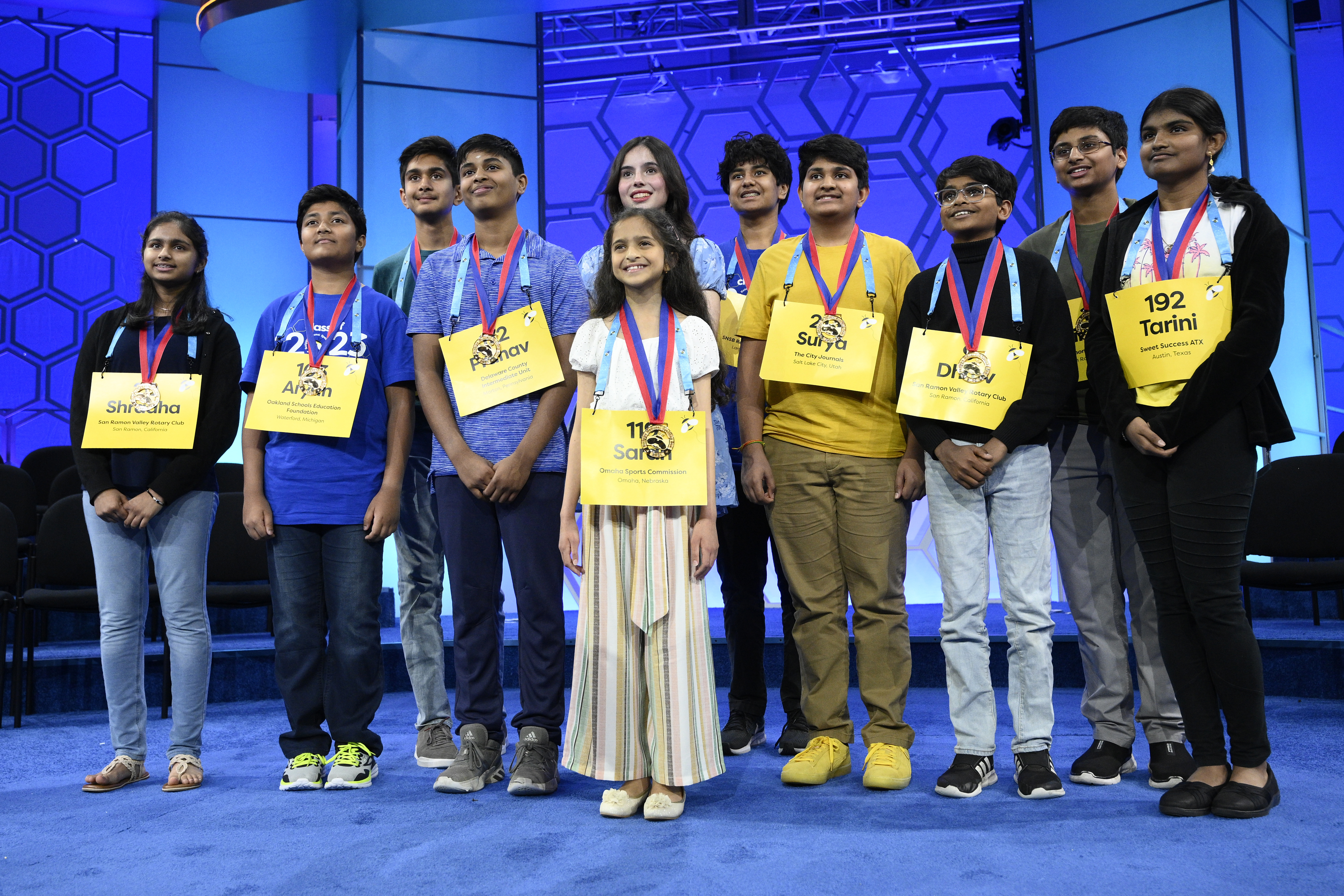 The 11 finalists for the Scripps National Spelling Bee pose for a picture after the day's competition, Wednesday in Oxon Hill, Md. Left to right-Shradha Rachamreddy, 13, from San Jose, Calif., Aryan Khedkar, 12, from Rochester, Hills Mich., Arth Dalsania, 14, from Camarillo, Calif., Pranav Anandh, 14, from Glen Mills, Pa., Sarah Fernandes, 11, from Omaha, Neb., Charlotte Walsh, 14, from Arlington, Va., Dev Shah, 14, from Largo, Fla., Surya Kapu, 14, from South Jordan, Utah, Dhruv Subramanian, 12, from San Ramon, Calif., Vikrant Chintanaboina, 14, from San Jose, Calif., and Tarini Nandakumar, 12, from Round Rock, Texas.
