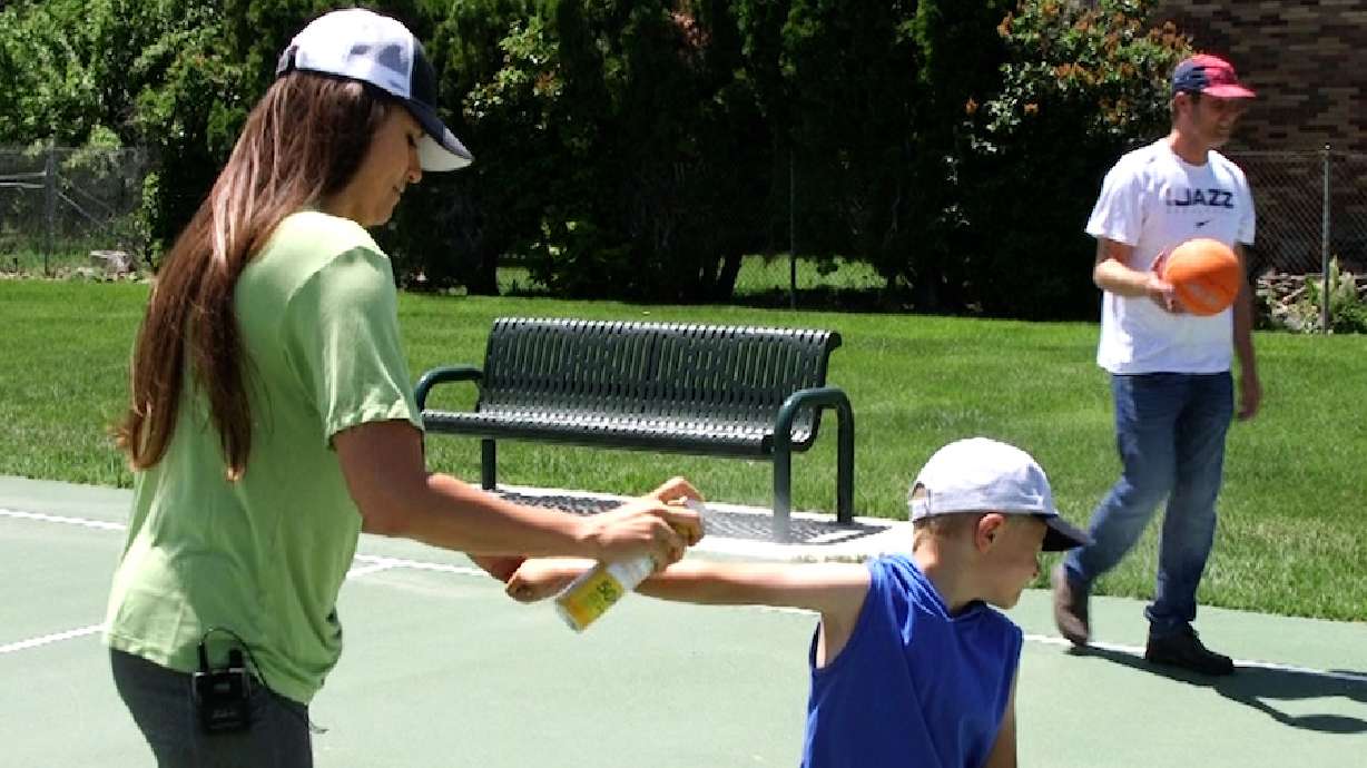 Amanda Jorgensen applies sunscreen to one of her children. Jorgensen was diagnosed with melanoma 12 years ago.