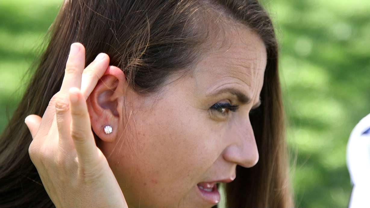 Amanda Jorgensen applies sunscreen to her right ear, where the cancerous mole was first discovered.