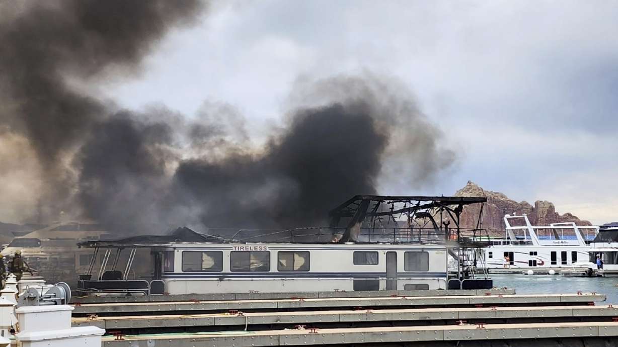 Smoke rises from a fire on Friday at Wahweap Marina on Lake Powell near Page, Ariz. More than half a dozen house boats momentarily caught fire at a popular boating destination on the Utah-Arizona line on Friday.