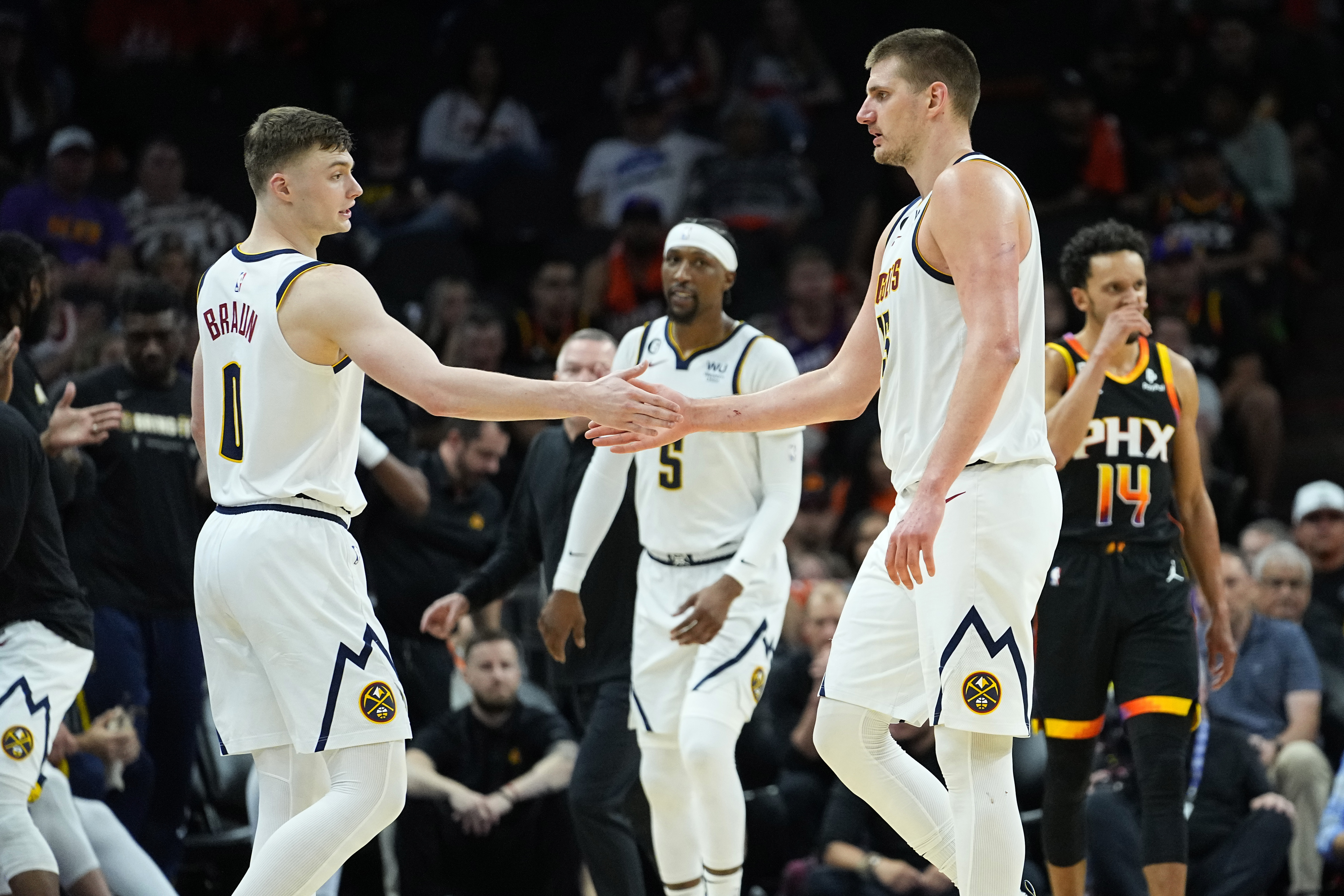 Denver Nuggets center Nikola Jokic, right, greets guard Christian Braun leaves the game during the second half of Game 6 of an NBA basketball Western Conference semifinal game against the Phoenix Suns, Thursday, May 11, 2023, in Phoenix. The Nuggets eliminated the Sun in their 125-100 win.