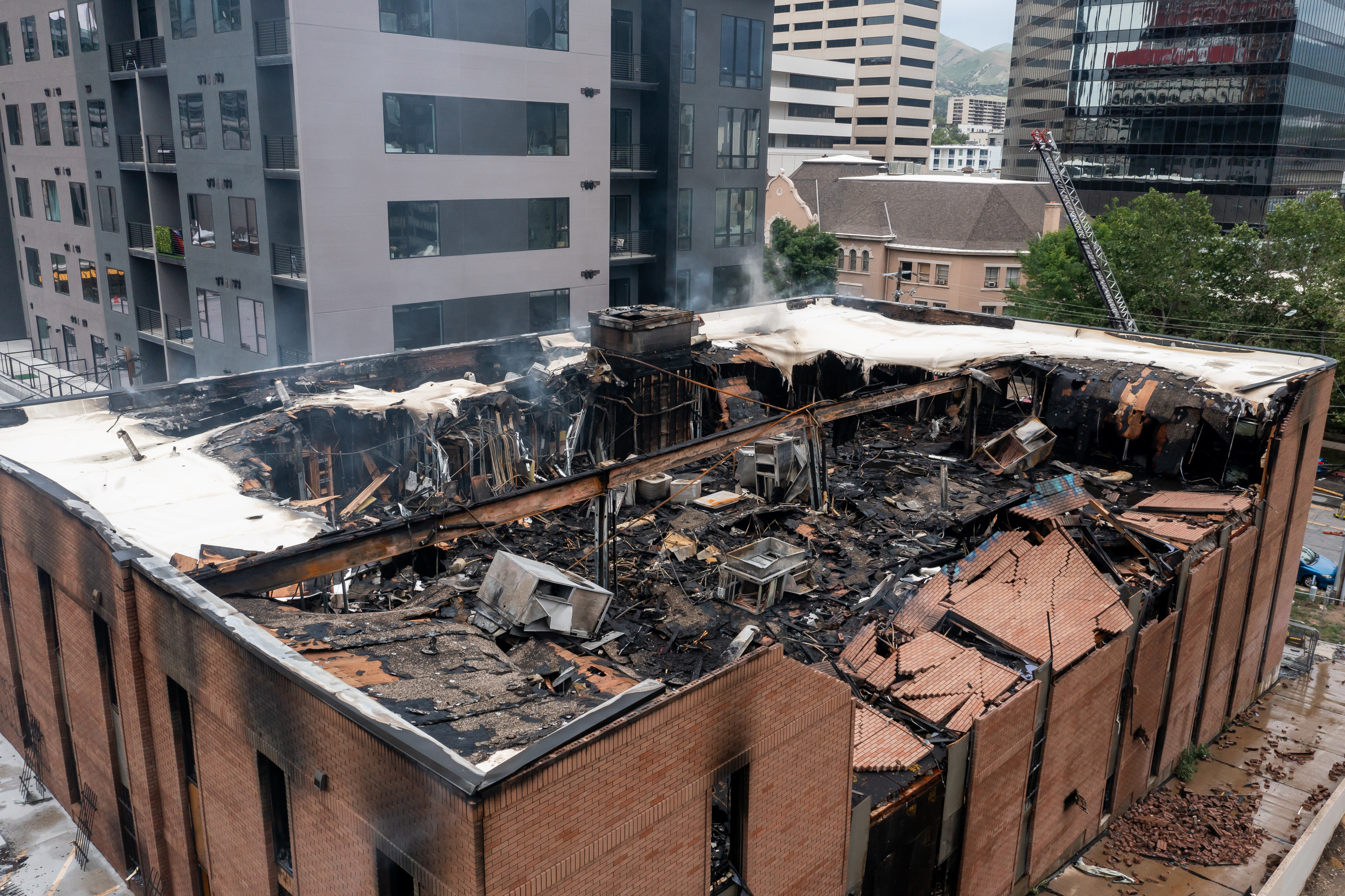The still-smoldering remains of a vacant building at 220 S. 200 E. in Salt Lake City that caught fire late Friday night are pictured in the afternoon on Saturday.