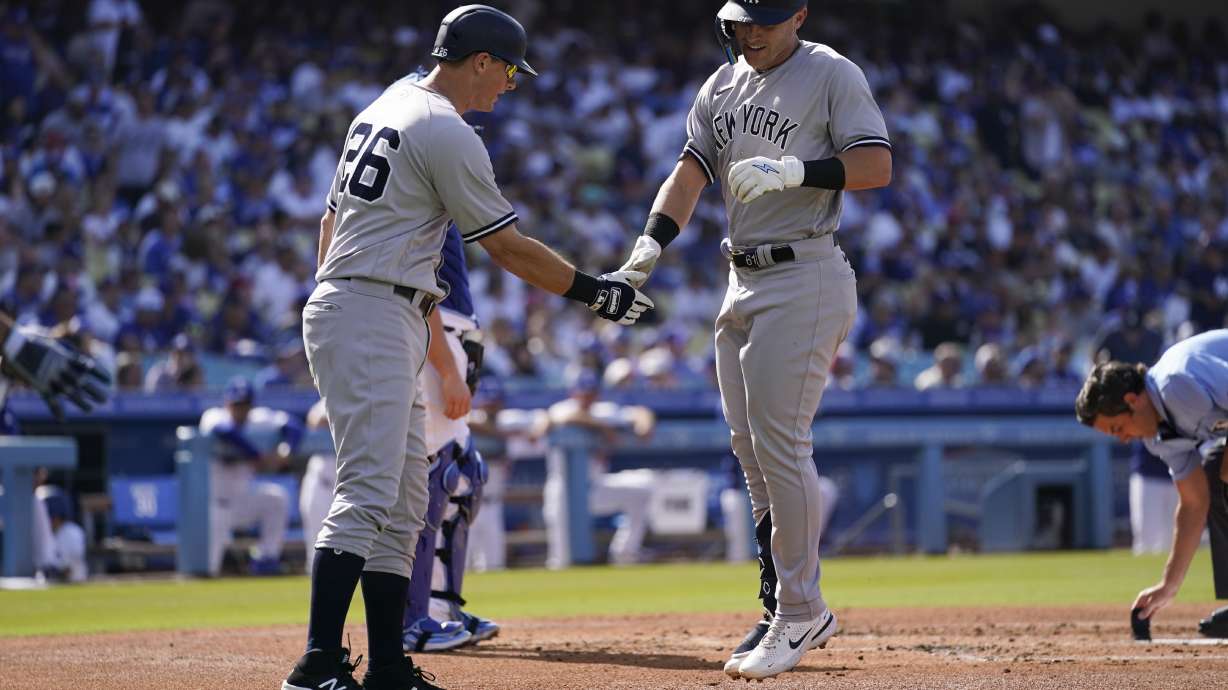 New York Yankees' Jake Bauers (61) celebrates with DJ LeMahieu (26) after they both scored off of a home run hit by Bauers during the second inning of a baseball game against the Los Angeles Dodgers in Los Angeles, Saturday, June 3, 2023.