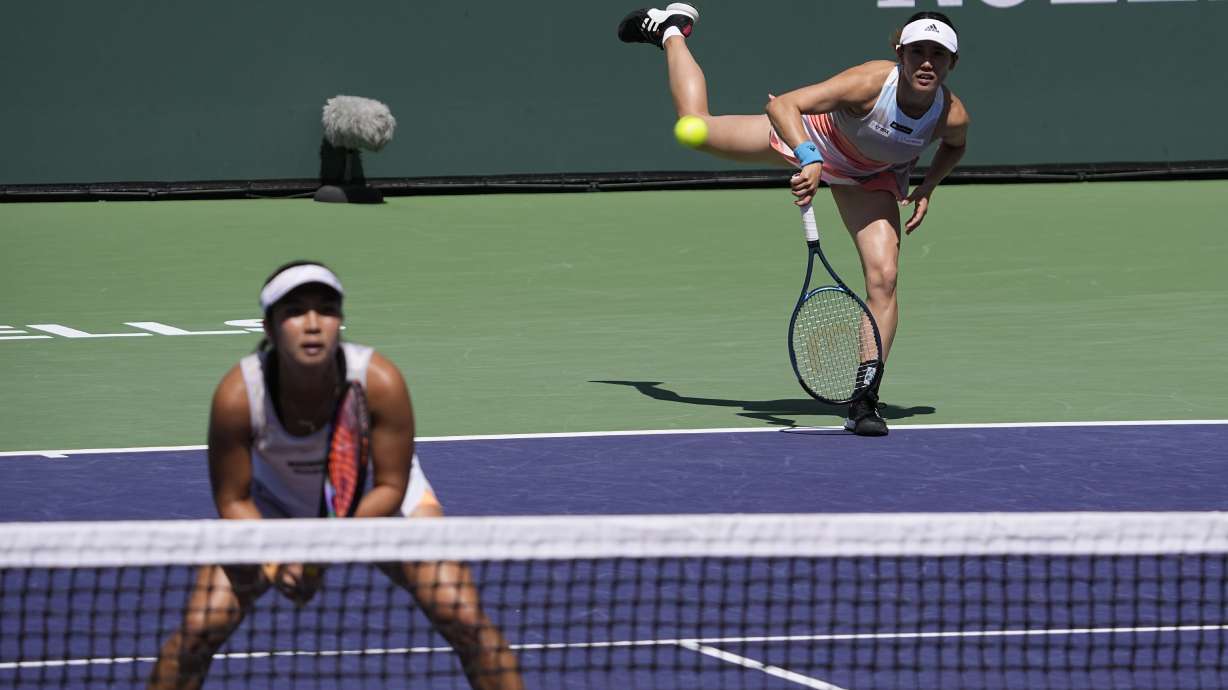 FILE - Miyu Kato, of Japan, right, serves behind her partner Aldila Sutjiadi, of Indonesia, as they play against Beatriz Haddad Maia, of Brazil, and Laura Siegemund, of Germany, in a doubles semifinal match at the BNP Paribas Open tennis tournament Friday, March 17, 2023, in Indian Wells, Calif. French Open doubles player Miyu Kato and her partner Aldila Sutjiadi have been forced to forfeit a match when Kato accidentally hit a ball girl in the neck with a ball after a point during their match against Marie Bouzkova and Sara Sorribes Tormo on Sunday, June 4, 2023.