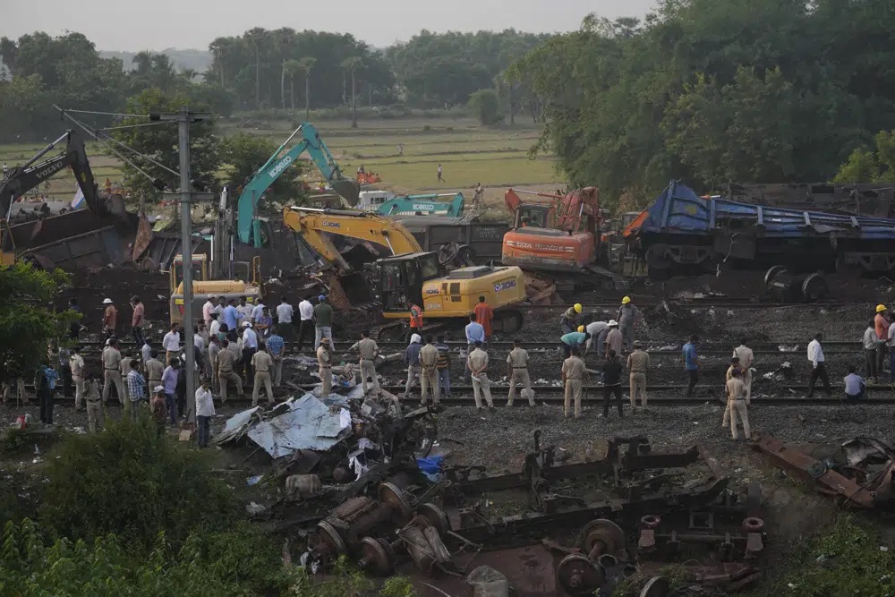 Policemen stand guard at the site where trains that derailed, in Balasore district, in the eastern Indian state of Orissa, Sunday. Indian authorities end rescue work and begin clearing mangled wreckage of two passenger trains that derailed in eastern India, killing about 275 people and injuring hundreds in one of the country’s deadliest rail crashes in decades.