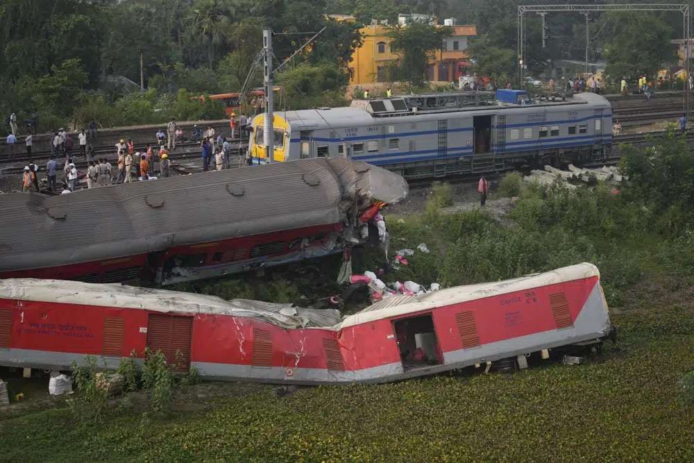 People watch the site where trains that derailed, in Balasore district, in the eastern Indian state of Orissa, Sunday. Indian authorities end rescue work and begin clearing mangled wreckage of two passenger trains that derailed in eastern India, killing about 275 people and injuring hundreds in one of the country’s deadliest rail crashes in decades.