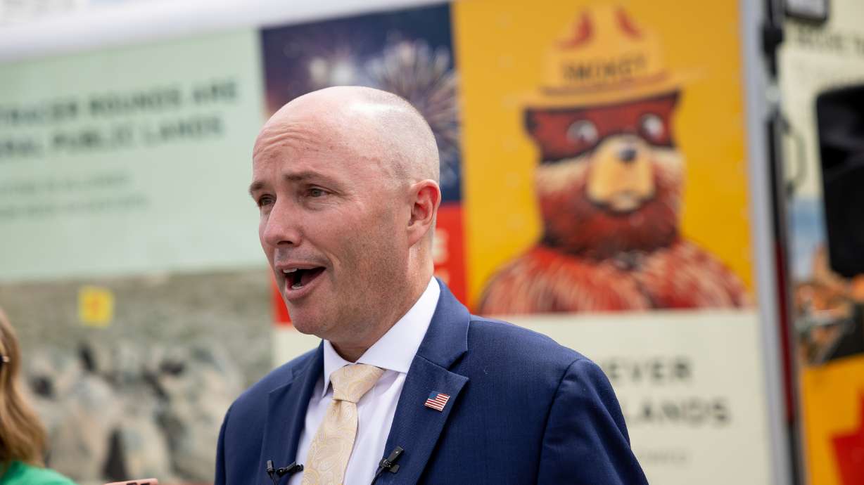 Gov. Spencer Cox speaks in front of a depiction of Smokey Bear during a press conference in North Salt Lake warning residents about wildfire risks on Monday.