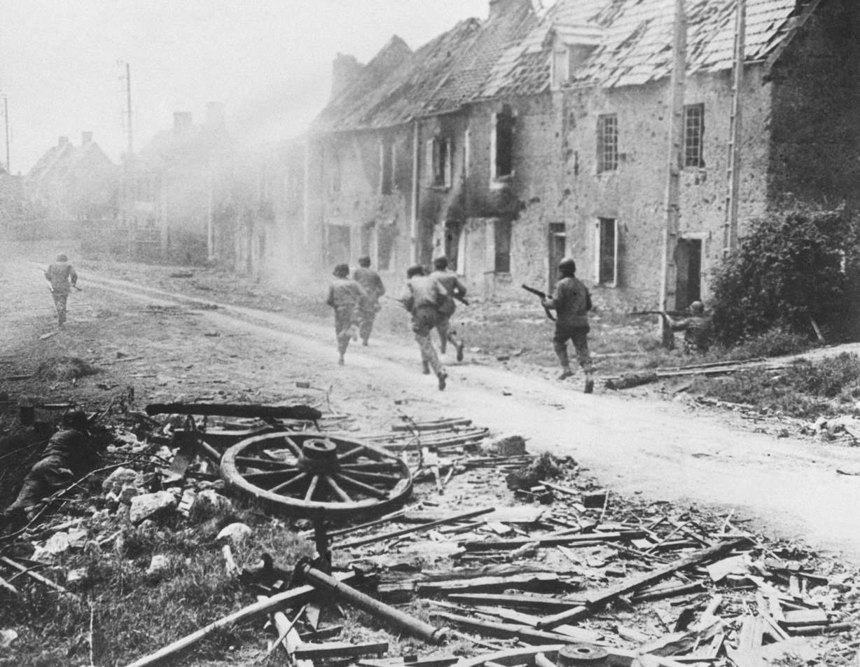 American infantrymen sprint down a village street in Normandy, July 27, 1944. The D-Day invasion that helped change the course of World War II was unprecedented in scale and audacity. Veterans and world dignitaries are commemorating the 79th anniversary of the operation.